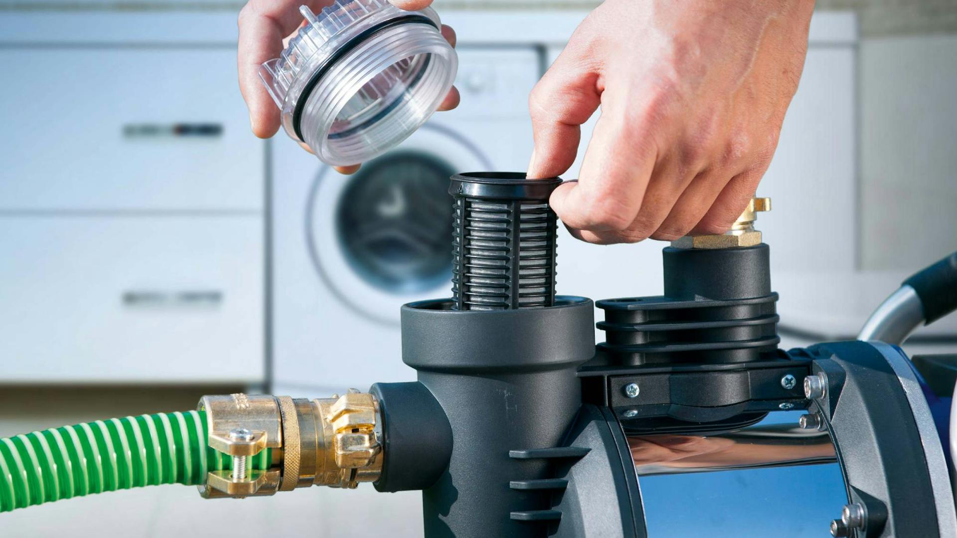 Una persona apre una pompa per acqua domestica davanti a una lavatrice