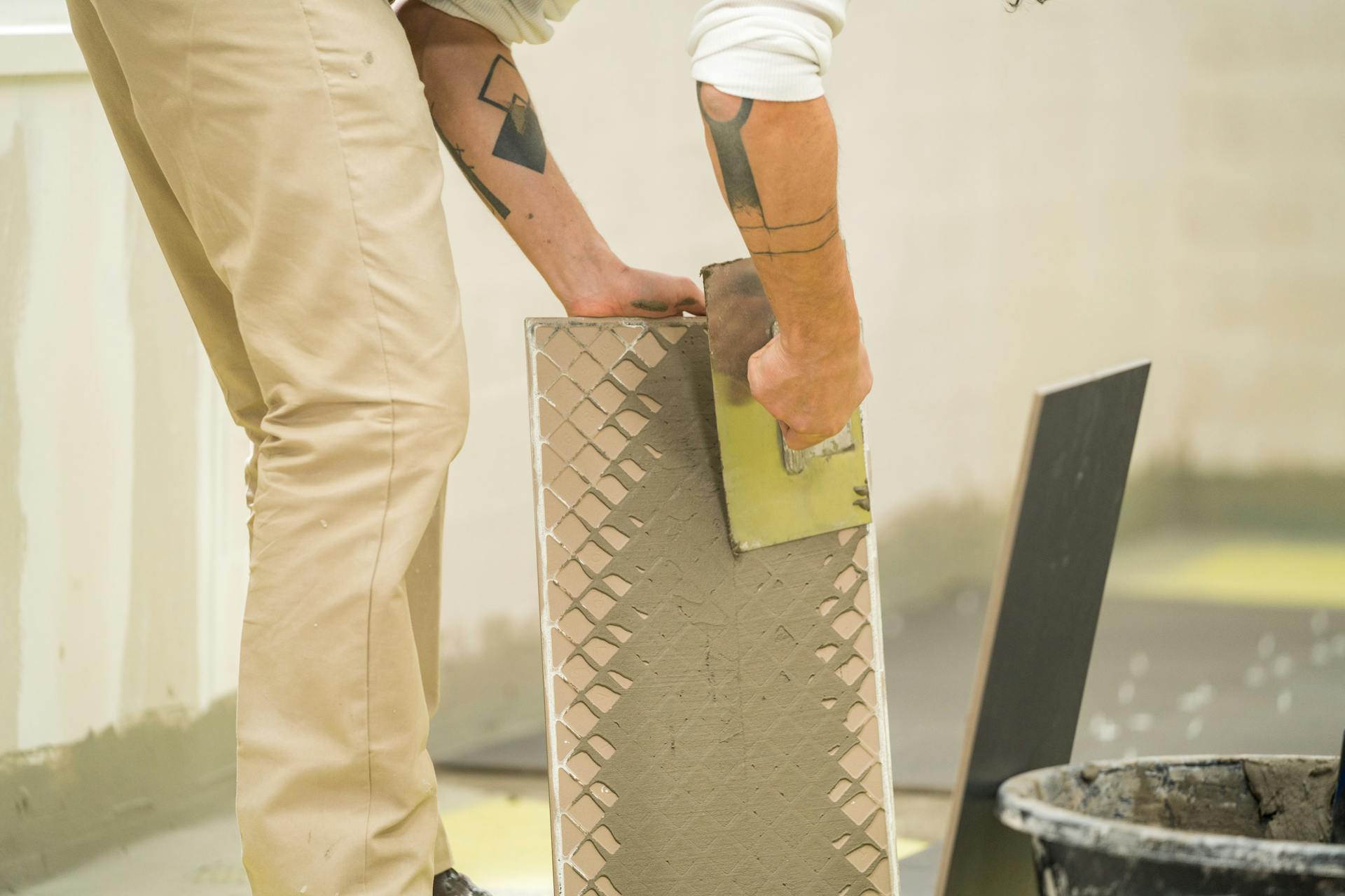 L’appassionato del fai-da-te applica la colla sul dorso delle piastrelle.