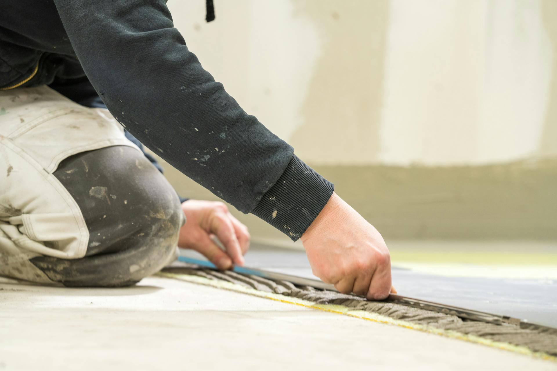 L’appassionato del fai da te posa le piastrelle dei bordi sulla colla.