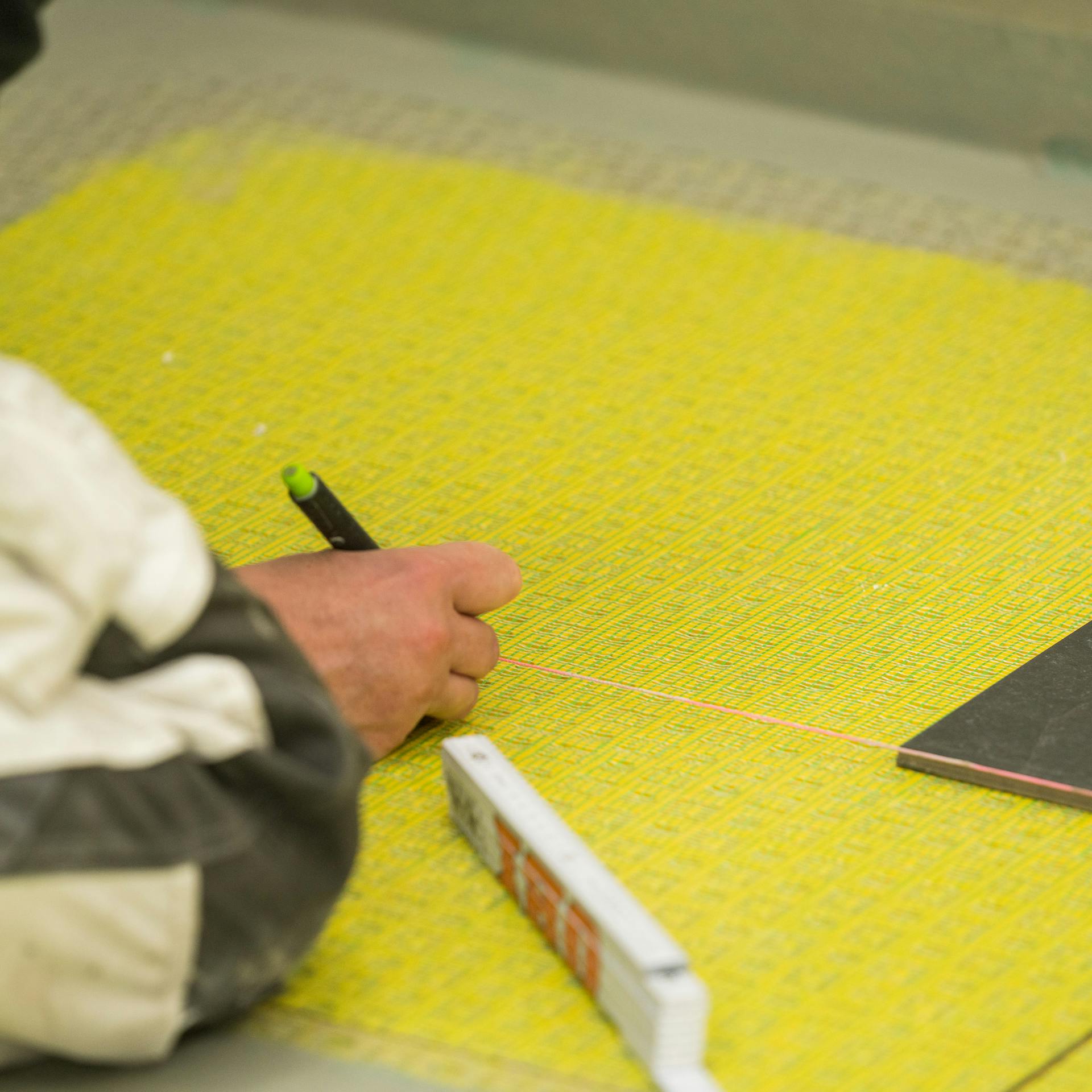 Heimwerker markiert mit einer Richtschnur den Verlauf der Fliesenreihen.