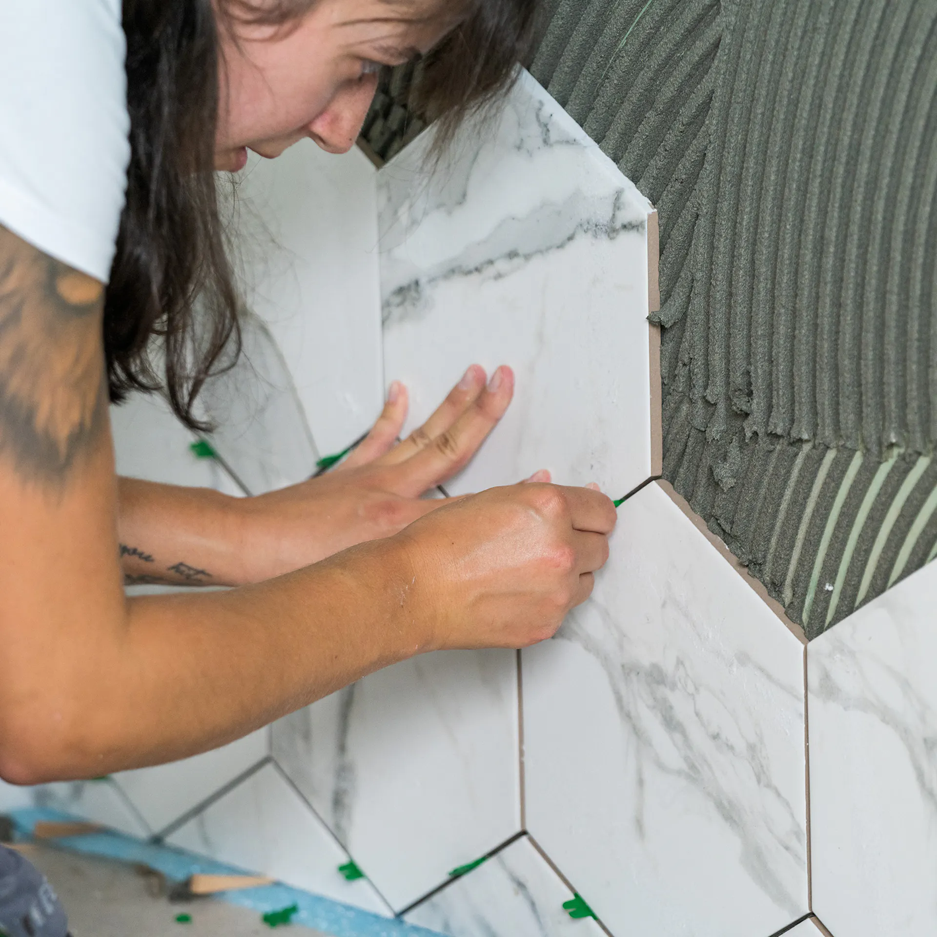 Fliese wird an die Wand geklebt