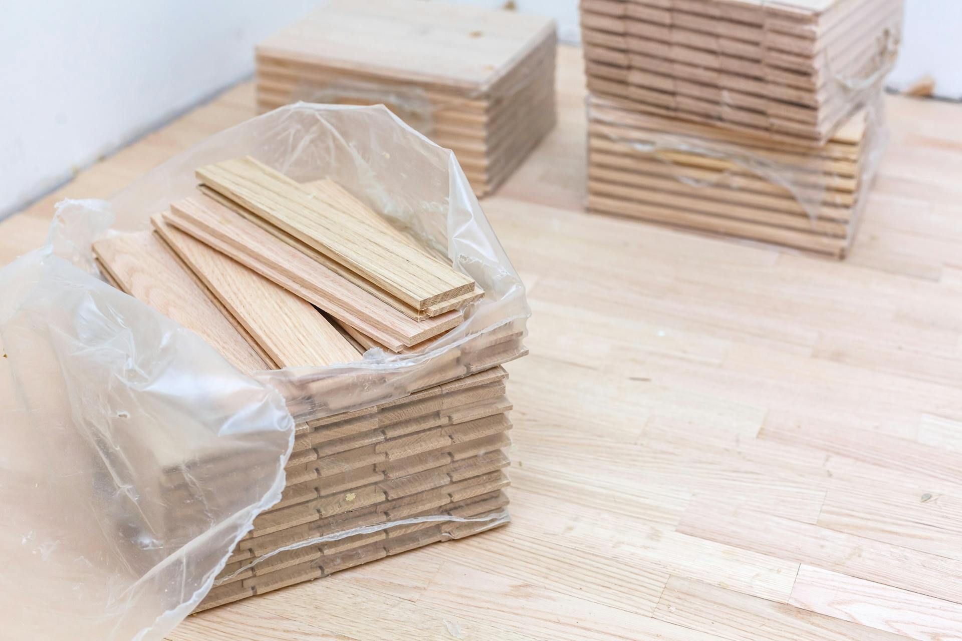 Egy csomag lécparketta egy parkettázott felületen