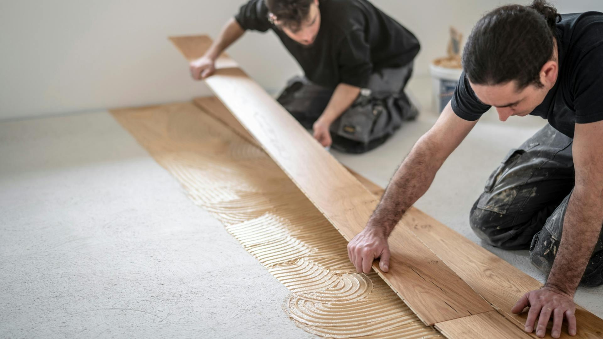 Dvaja muži ukladajú dvojvrstvové parkety