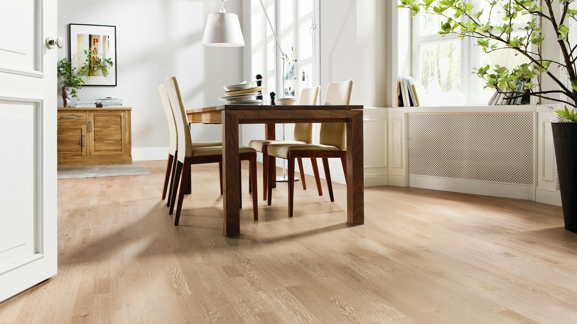 Un tavolo da pranzo in legno su un parquet di alta qualità.