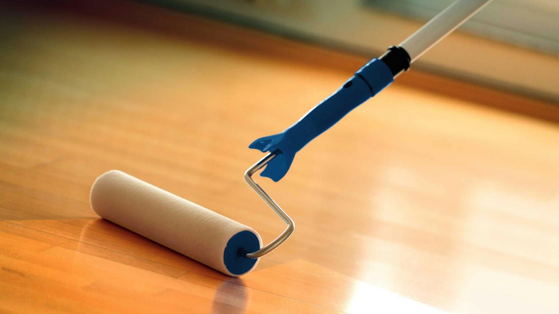 Das Parkett wird mit der Farbrolle versiegelt.