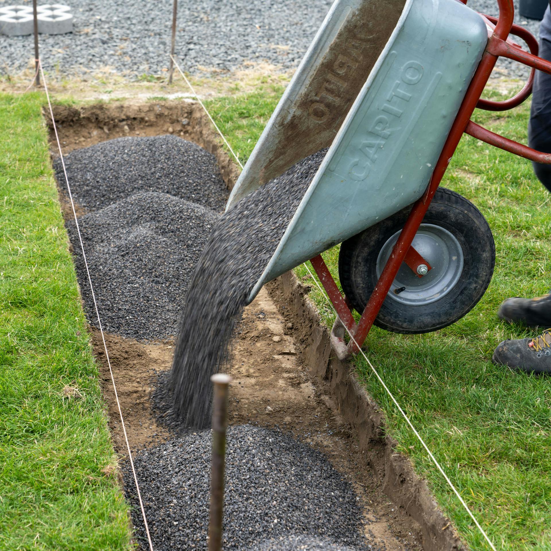 Sypanie drviny do vykopanej jamy z fúrika