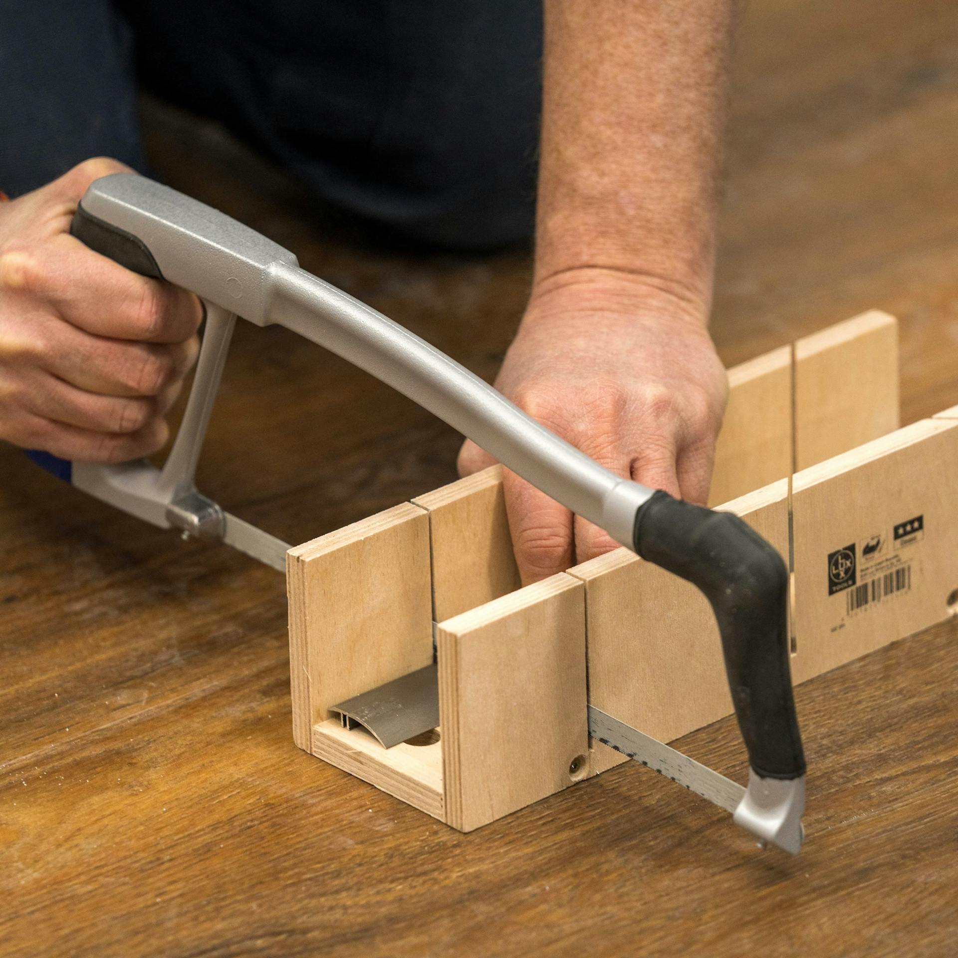 Heimwerker schneidet die Sockelleisten zu.