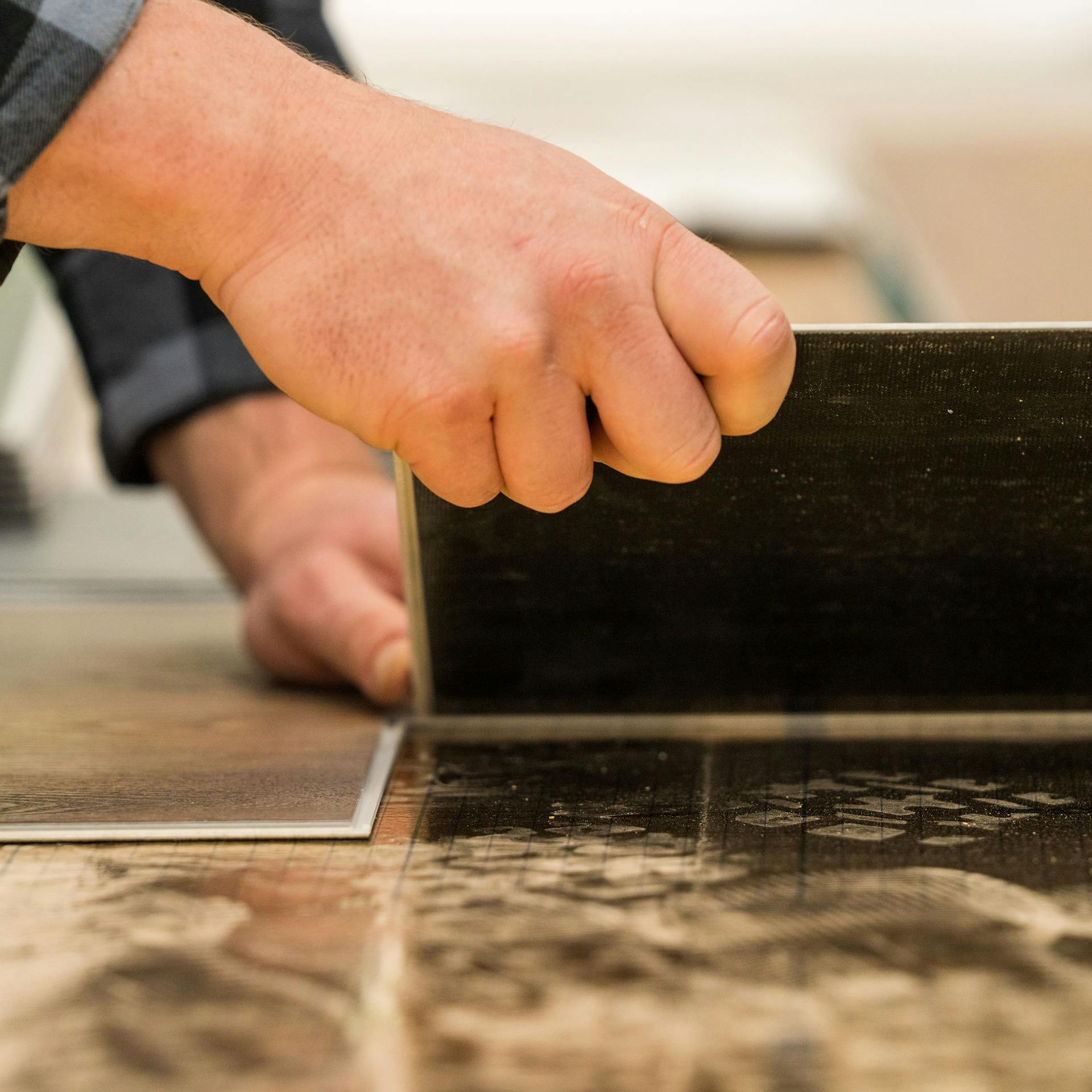 Handwerker verlegt Vinyl über der Trittschalldämmung.