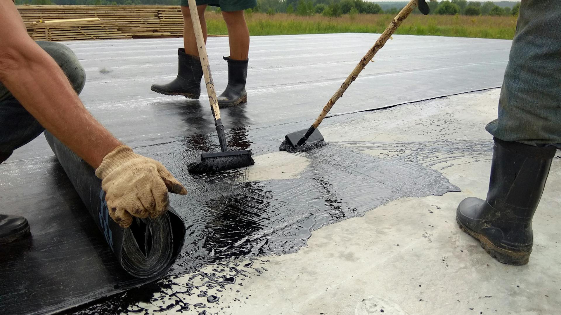 Mehrere Personen verlegen Dachbahnen