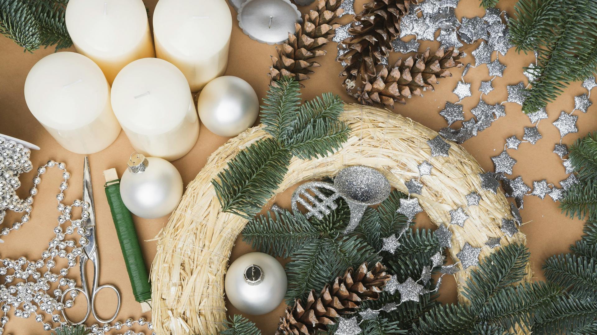 Verschiedene Materialien für einen Adventskranz liegen verteilt auf einem Tisch.