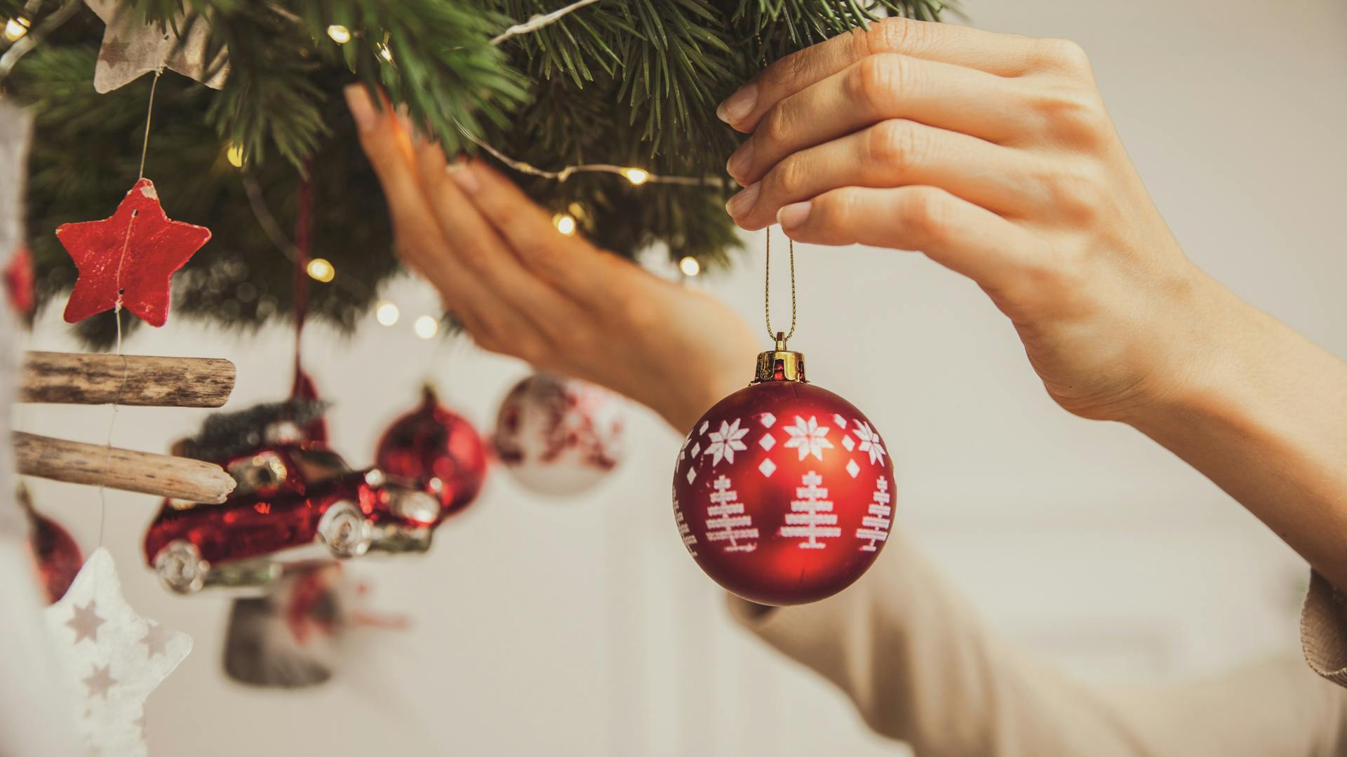 Bastelideen für Weihnachten mit Anleitung Deckenkranz Dekoration Christbaumkugel aufhängen Hände