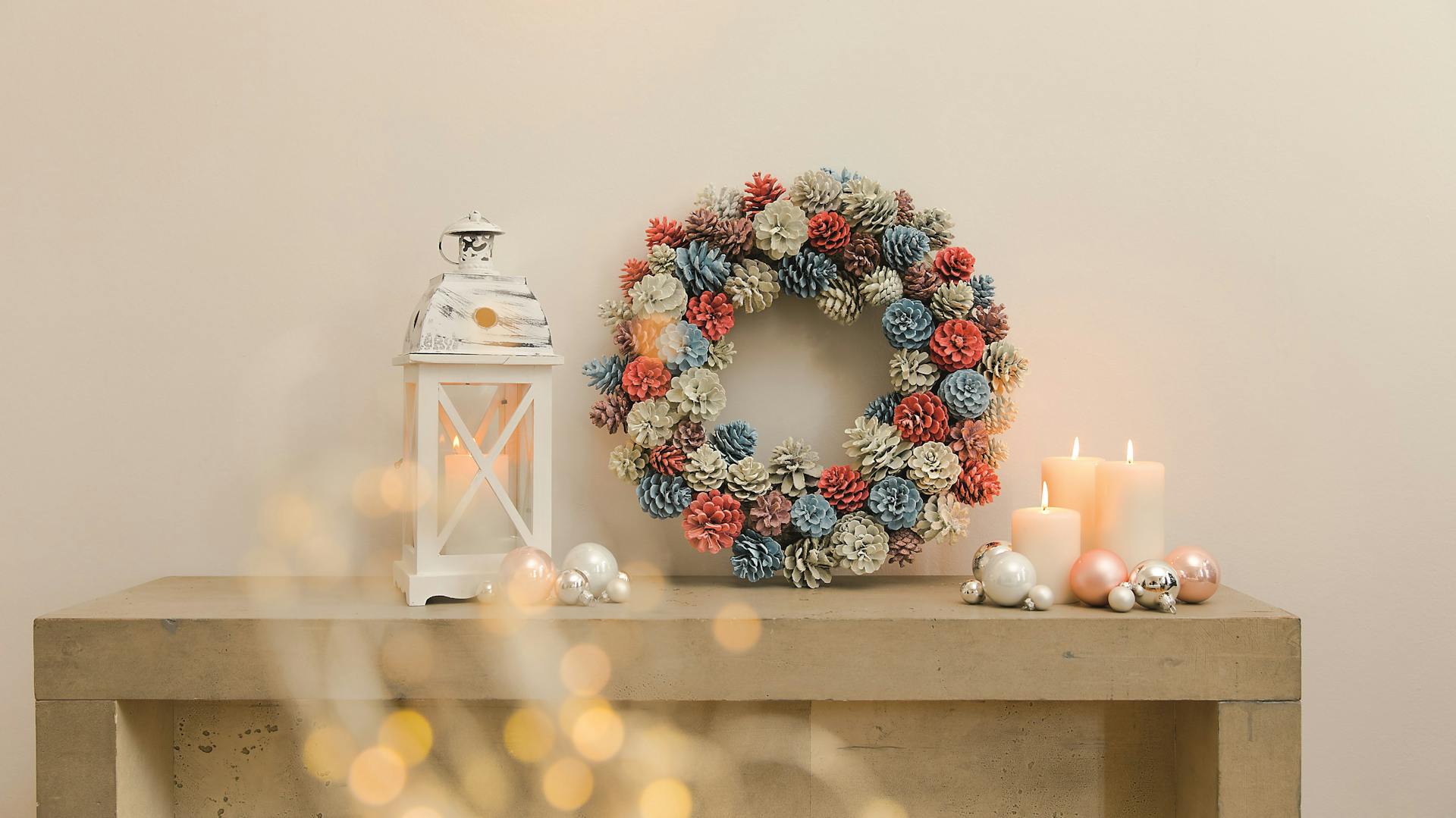 Kranz aus bunt bemalten Tannenzapfen als Deko auf Tisch