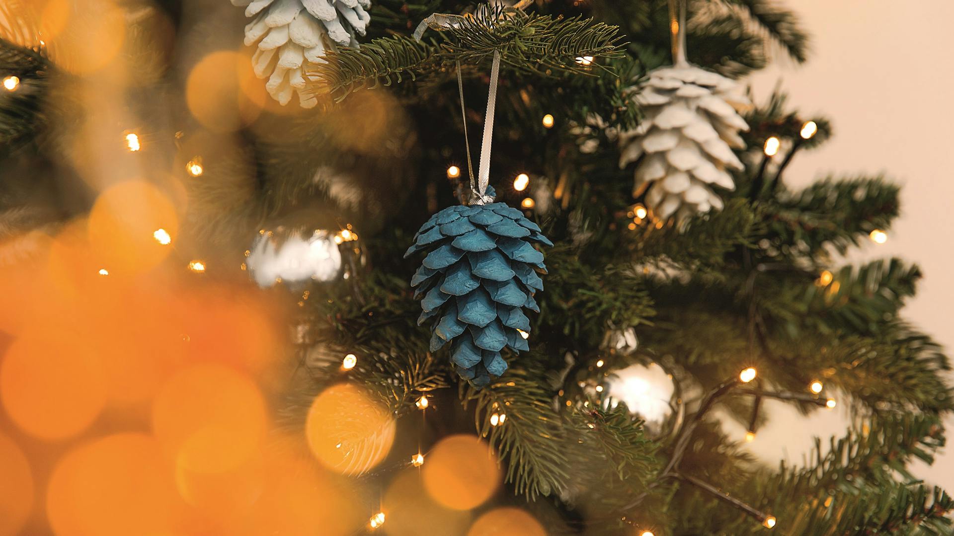 Weihnachtlich bemalte Tannenzapfen am Christbaum
