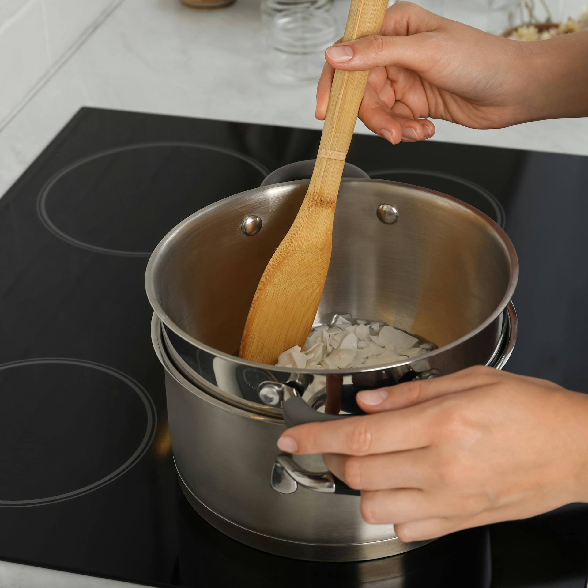 Jemand schmilzt Wachs in einem Kochtopf.