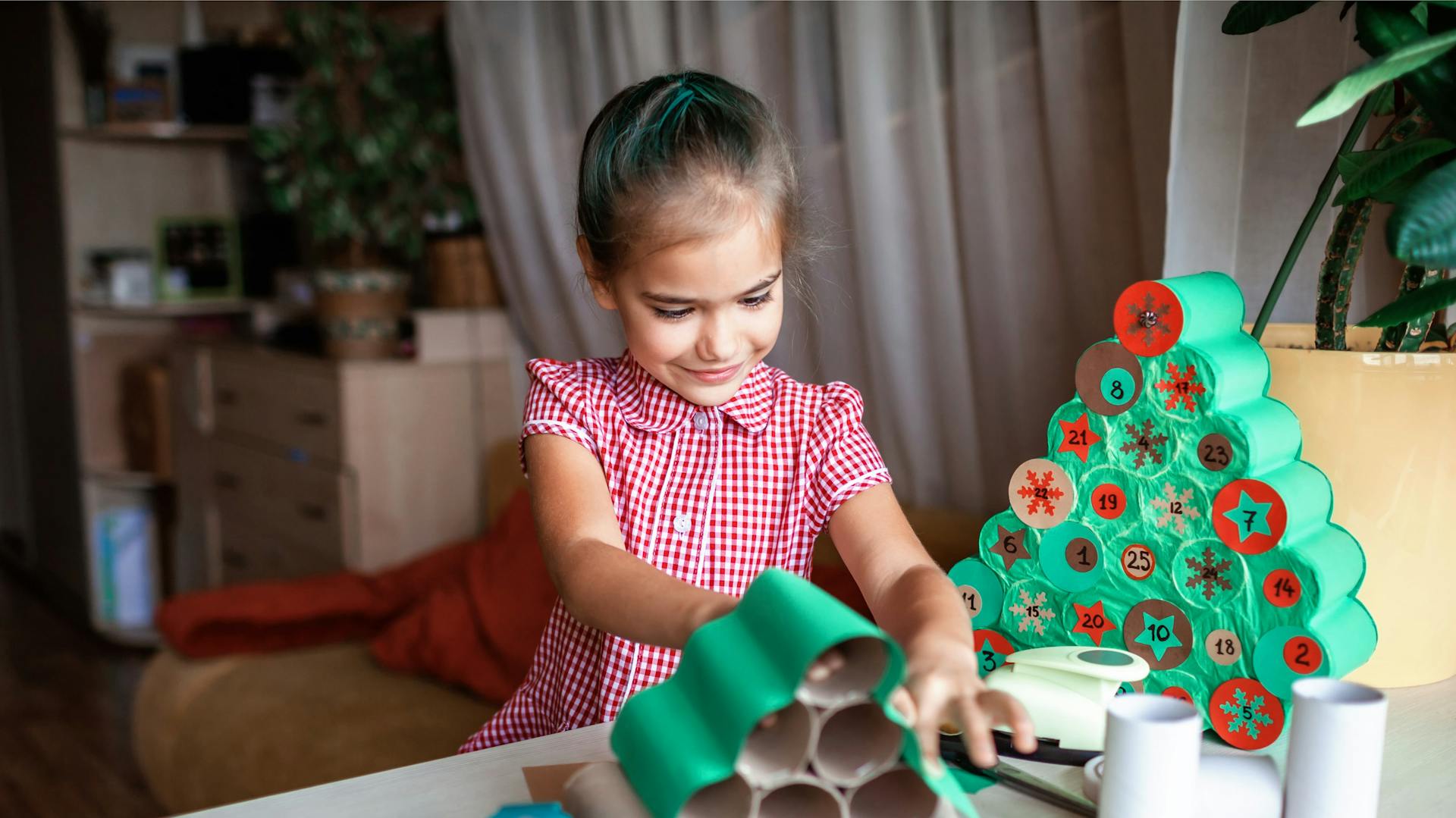 Kind bastelt Adventskalender aus Klorollen
