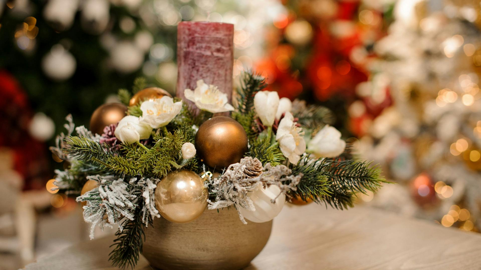 Composizione dell’Avvento in ciotola con palline di Natale dorate e una candela