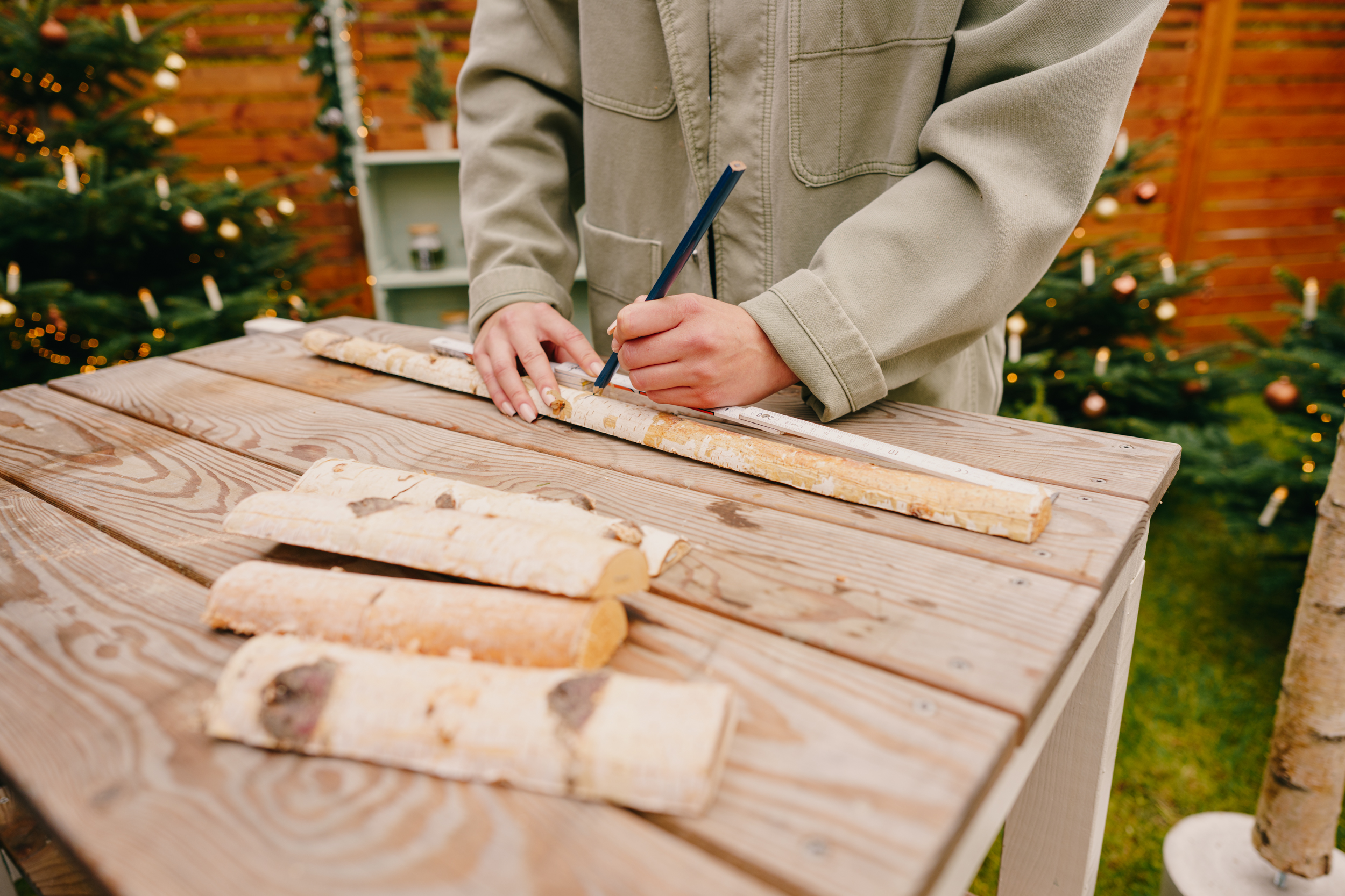Pracovníčka zakresľuje rozmery na brezové polokmene.