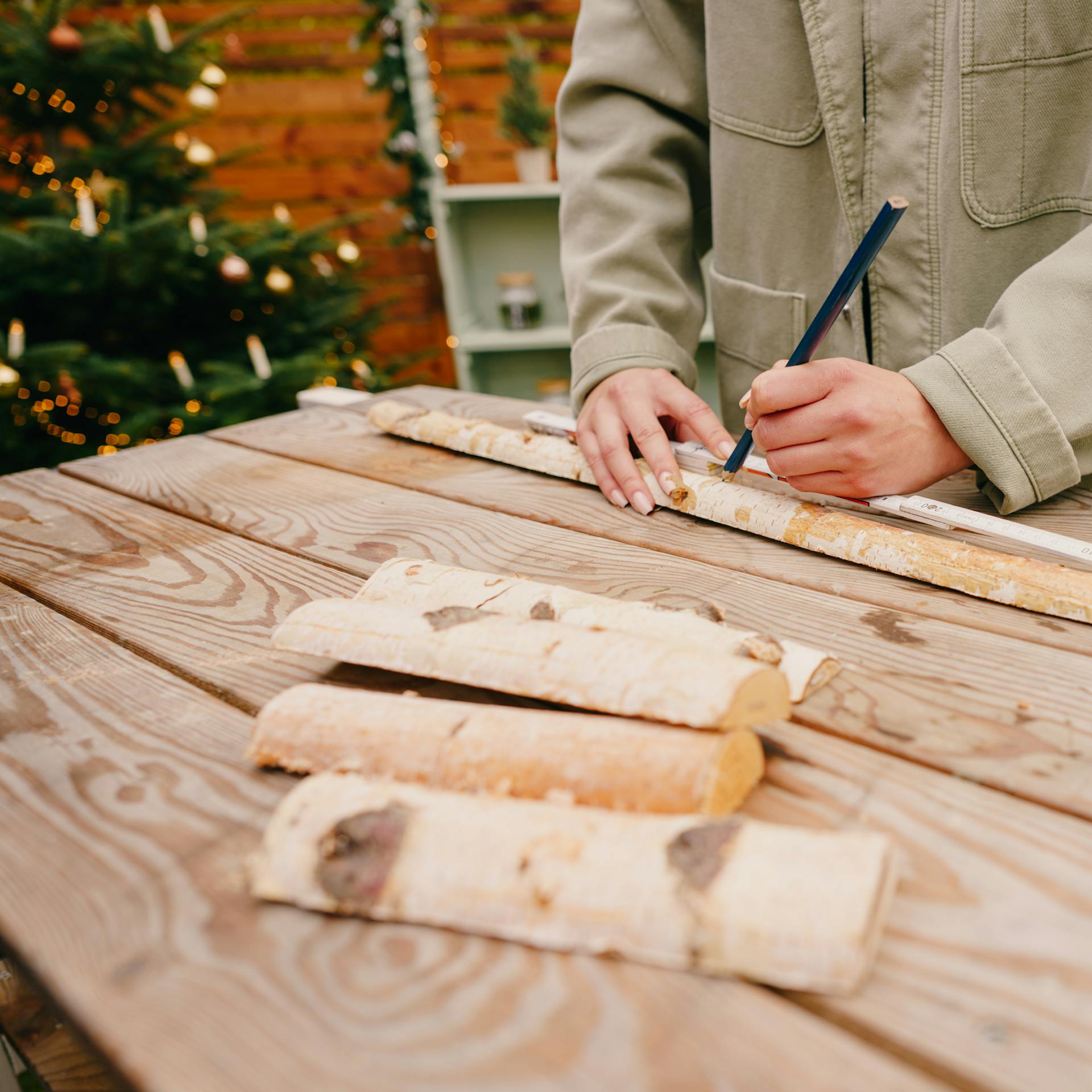 Pracovníčka zakresľuje rozmery na brezové polokmene.