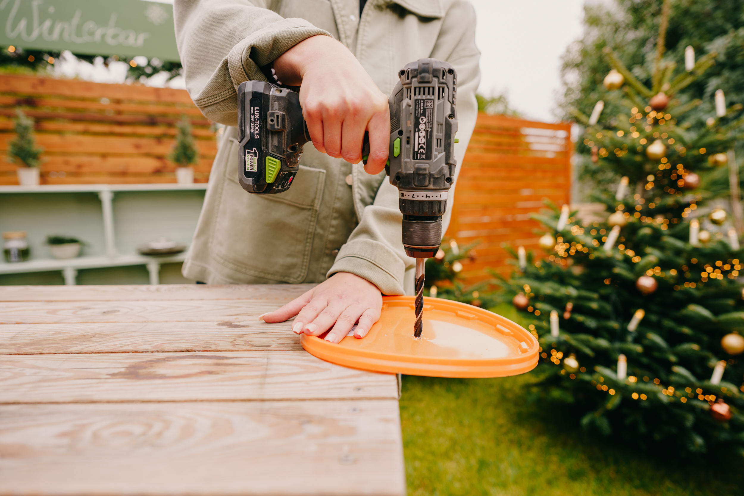 Pracovníčka vŕta otvor do veka vedra.