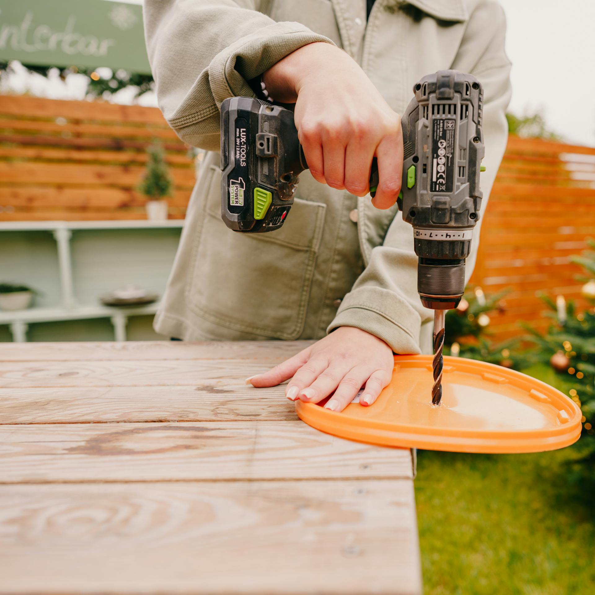 Pracovníčka vŕta otvor do veka vedra.