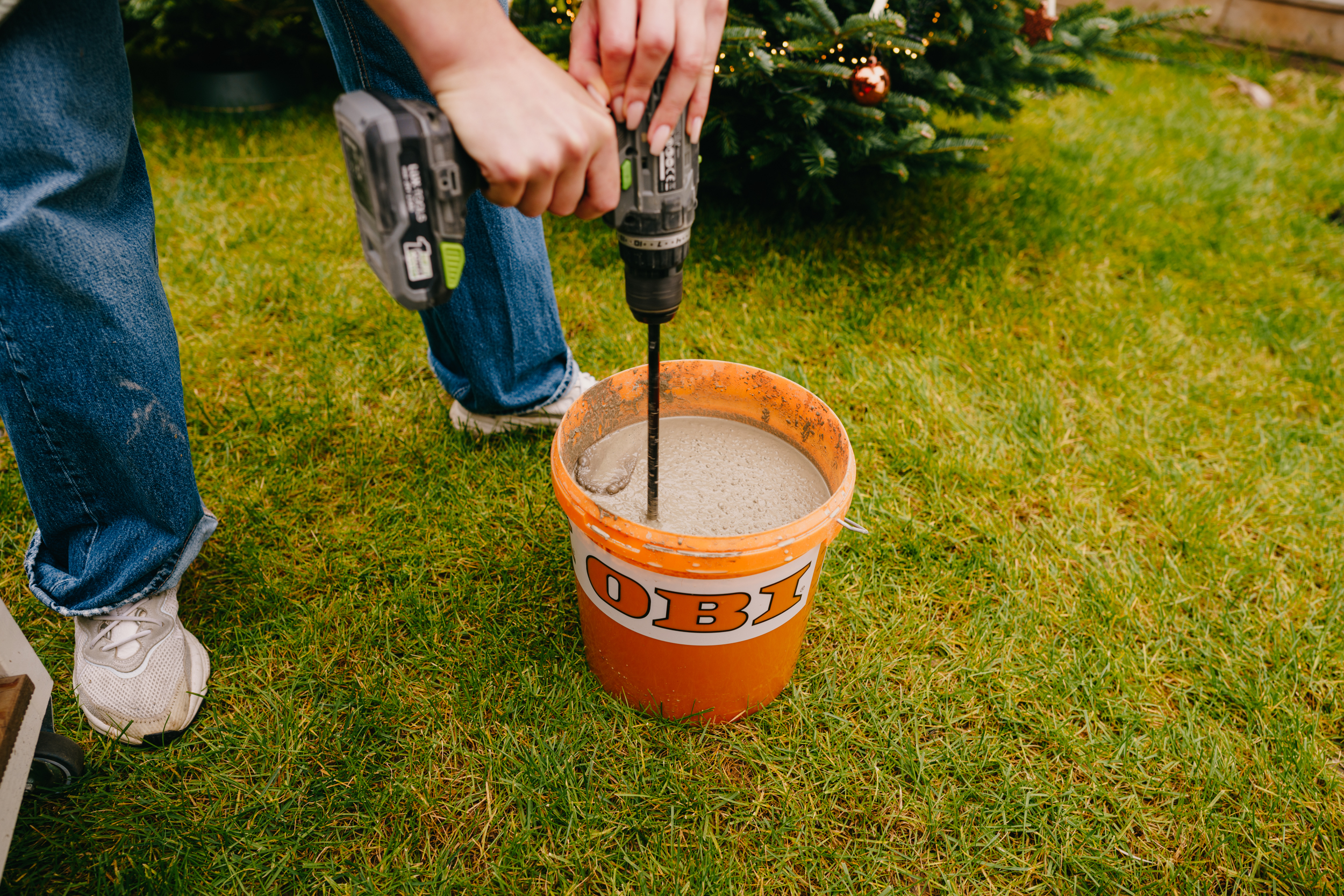 Pracovníčka mieša maltu vo vedre.