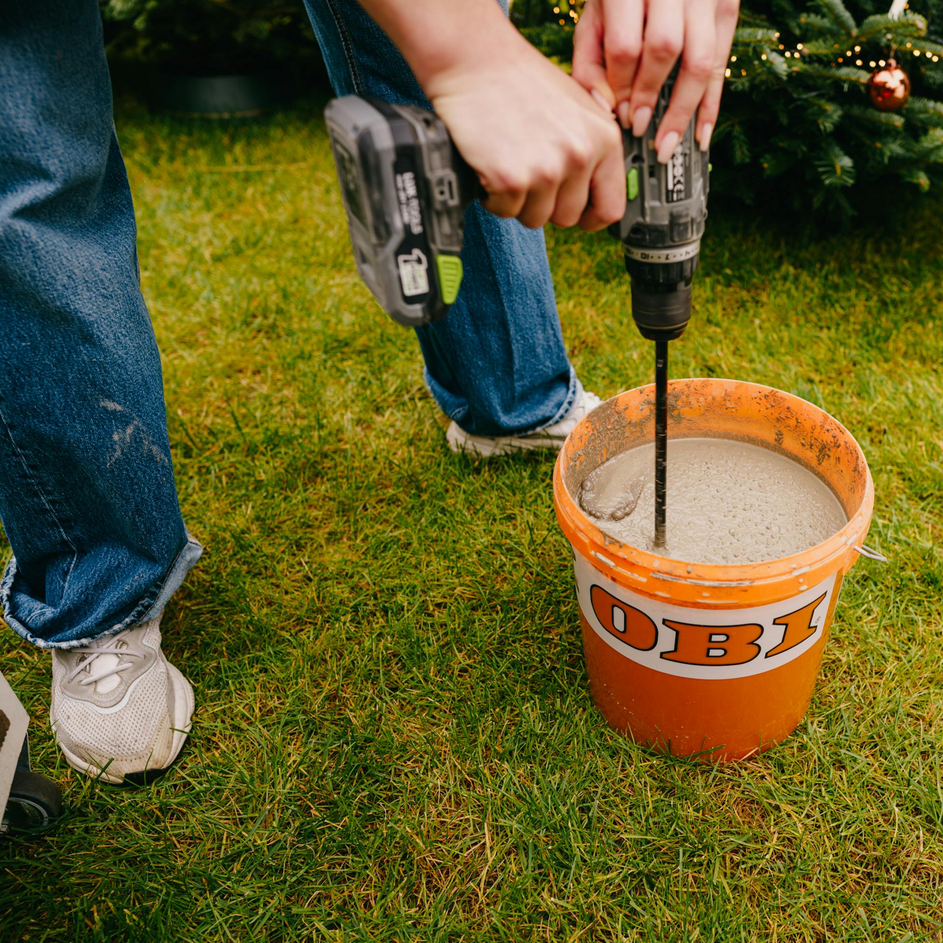 Pracovníčka mieša maltu vo vedre.