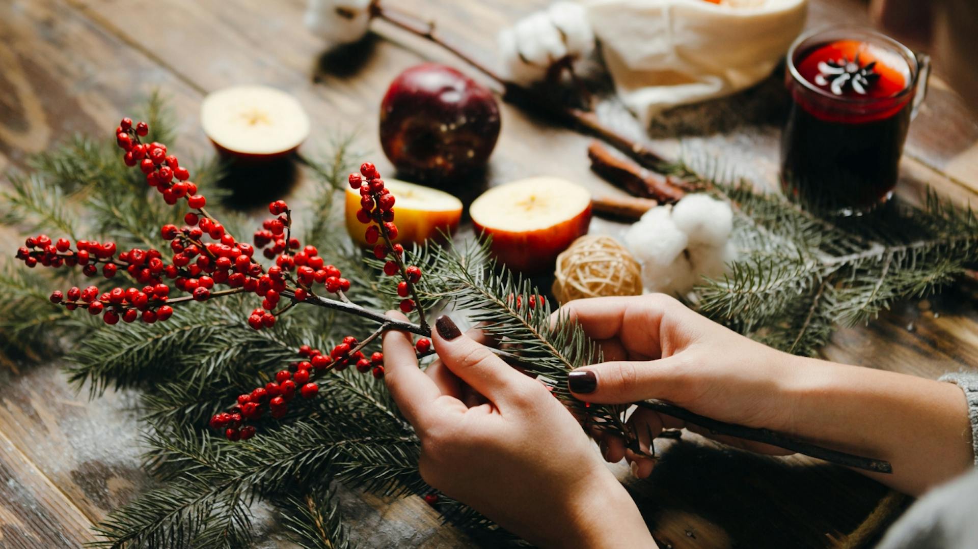 Mani di donna tengono il materiale inserito nella corona dell'Avvento.