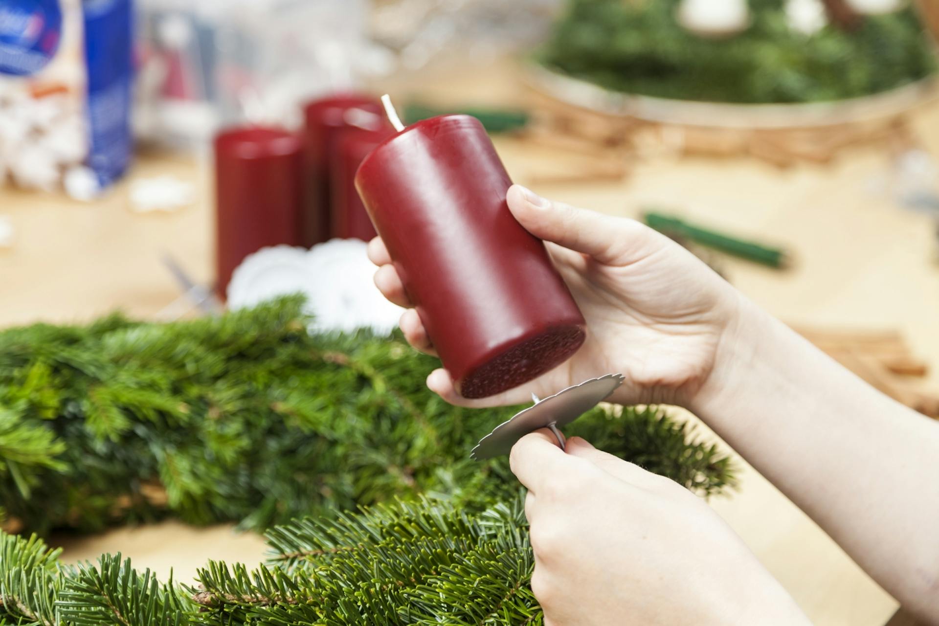Qualcuno fissa le candele sulla corona dell’Avvento.