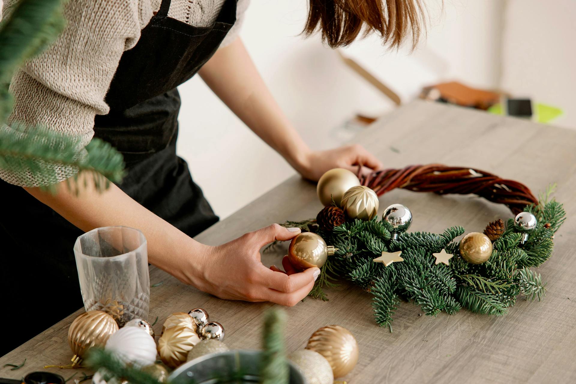 Qualcuno decora una corona di vimini con ramoscelli d’abete per l’Avvento.