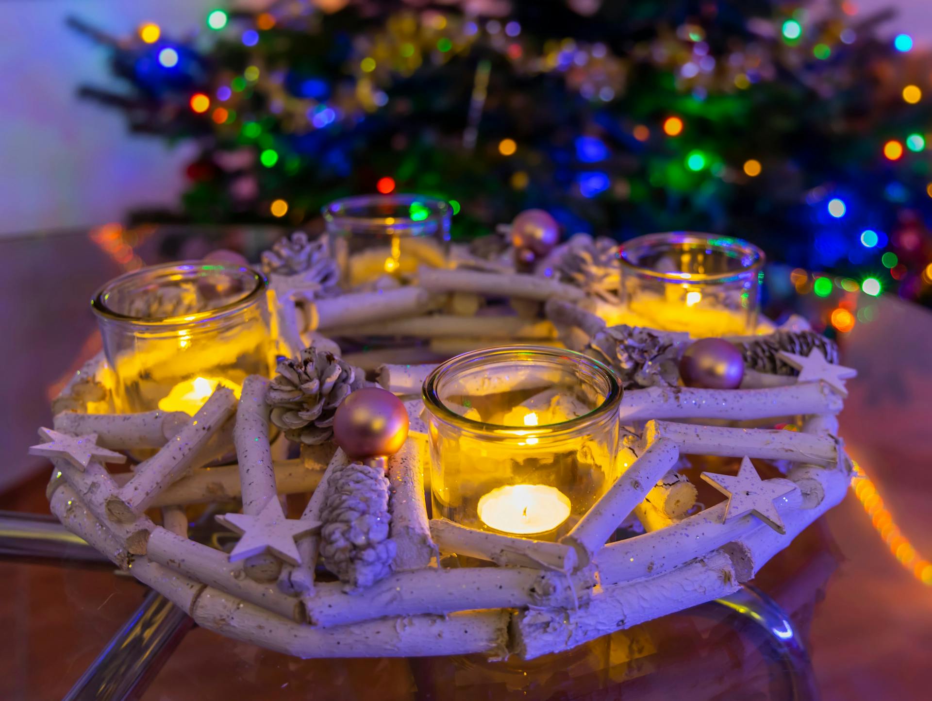 Una corona dell’Avvento in legno bianco è disposta su una tavola.