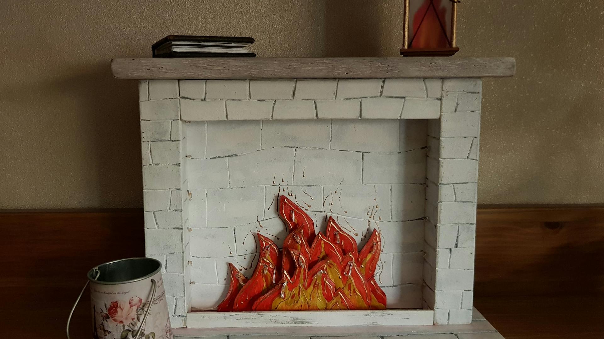 Weißer Dekokamin mit gebastelten Flammen