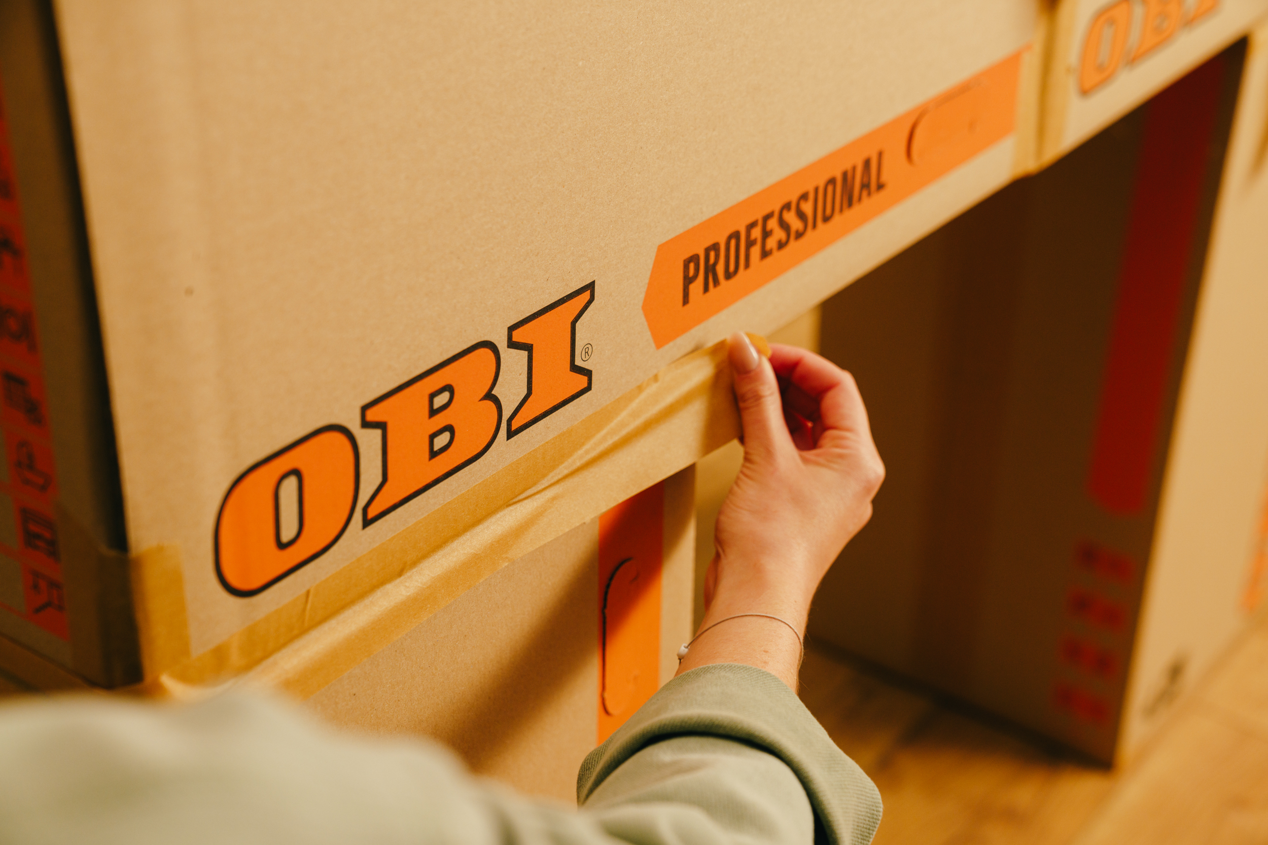 Egy barkácsoló kartondobozokat ragaszt össze.