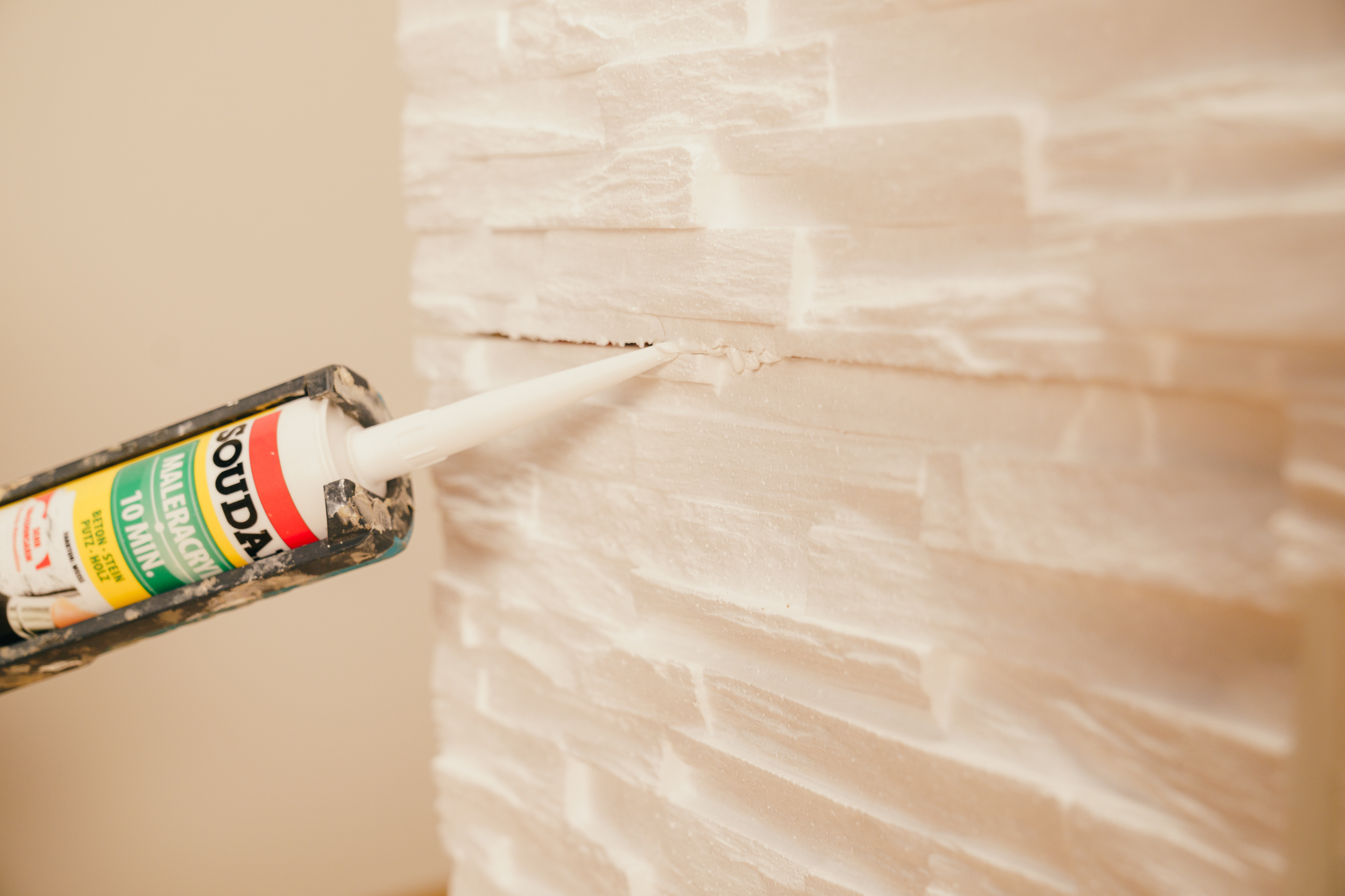 Egy barkácsoló akrillal tölti ki a hézagokat.