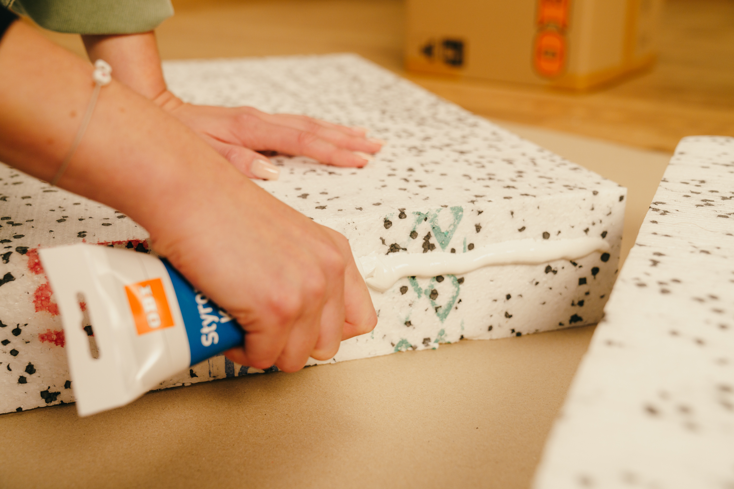 Egy barkácsoló lapokat ragaszt össze.