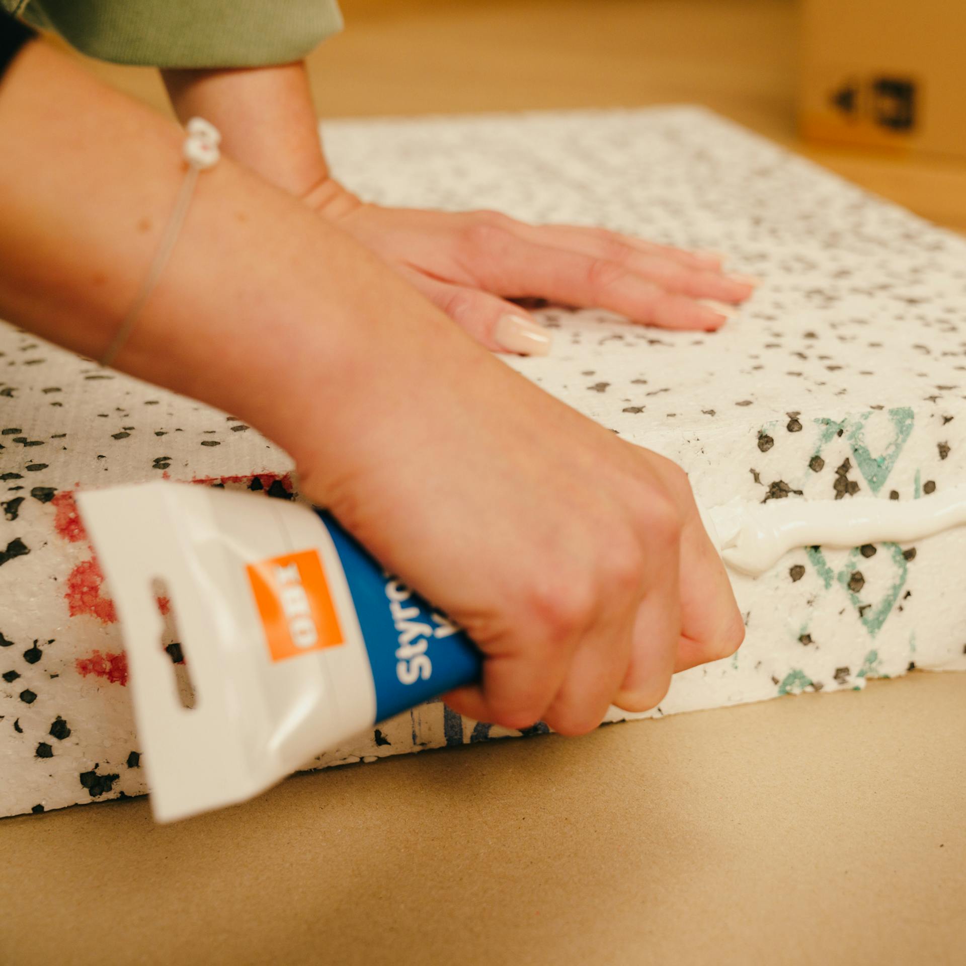 Die Handwerkerin verklebt die Platten miteinander.