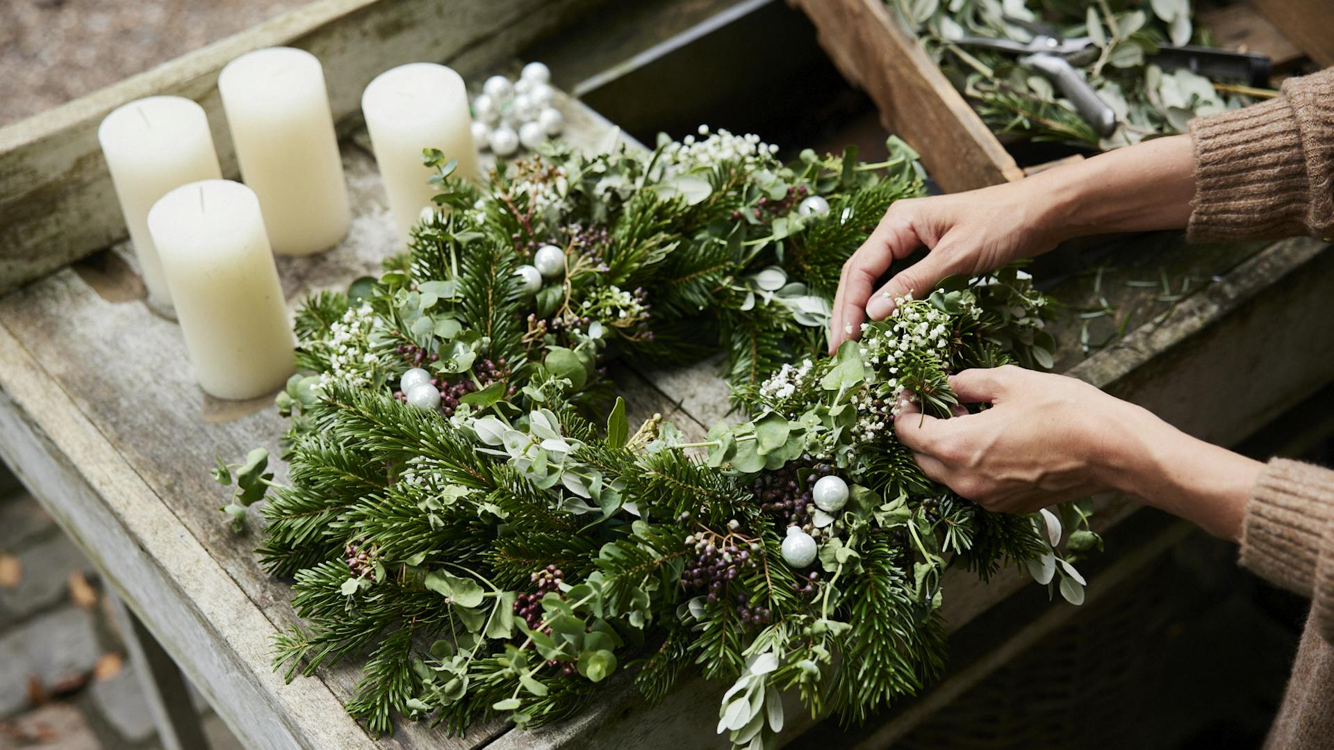 Adventskranz wird mit Dekoration bestückt