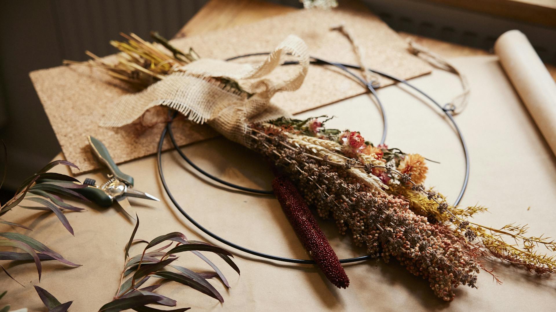 Ein großer Strauß wird auf einen Metallringe gebunden.