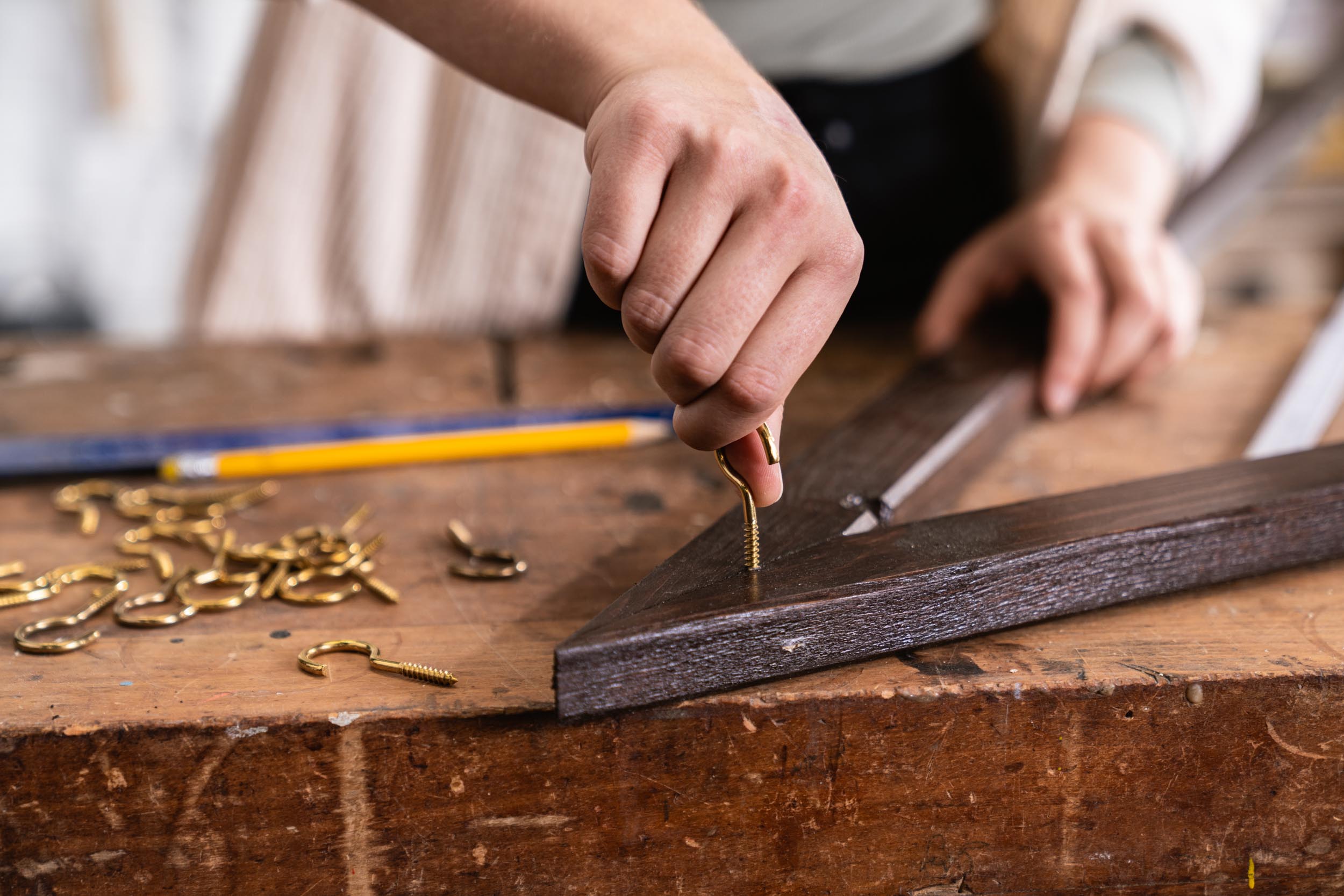 Csavaros kampókat csavaroznak a falifa keretének tetejére.