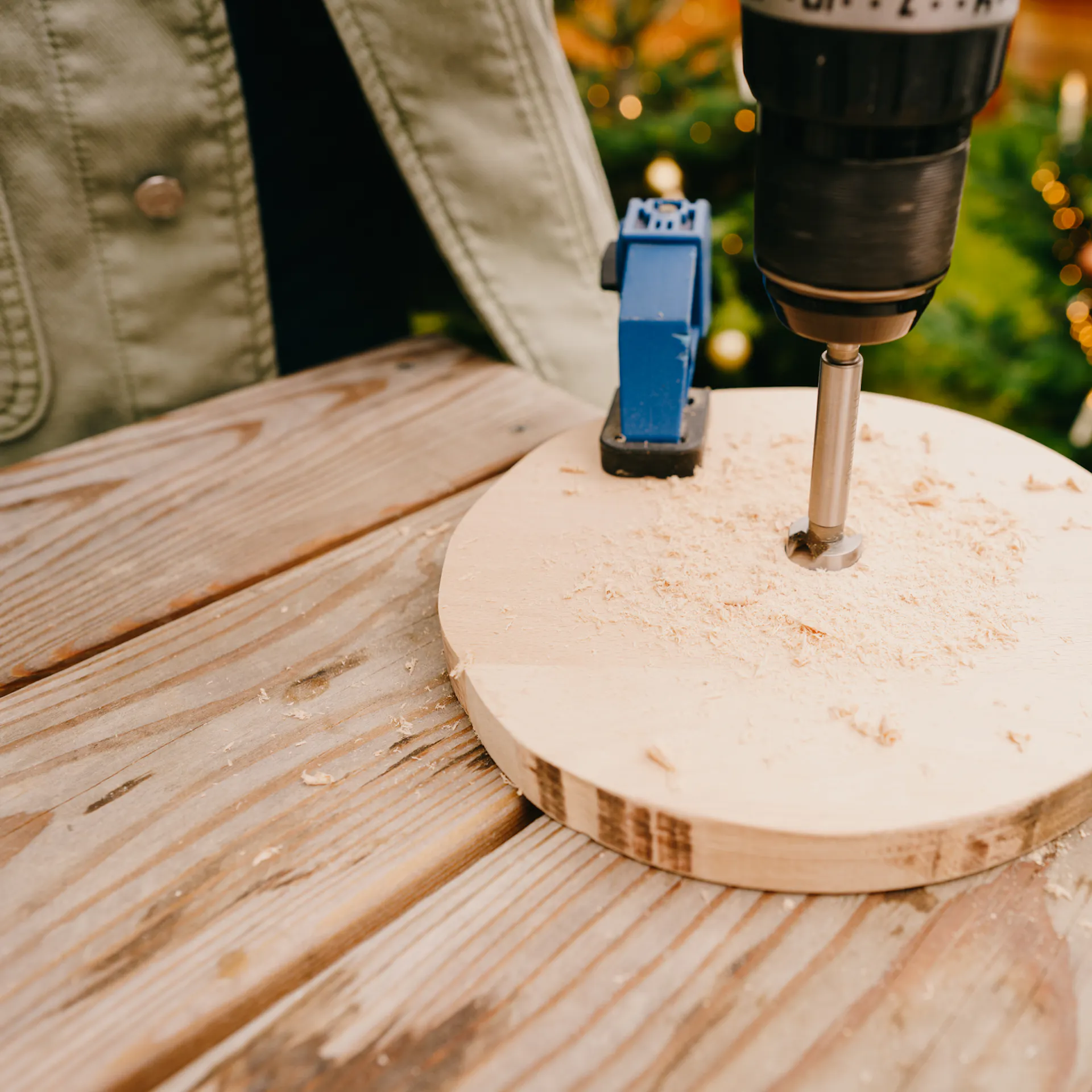 Řemeslnice vrtá pomocí Forstnerova vrtáku otvor do dřevěné desky.