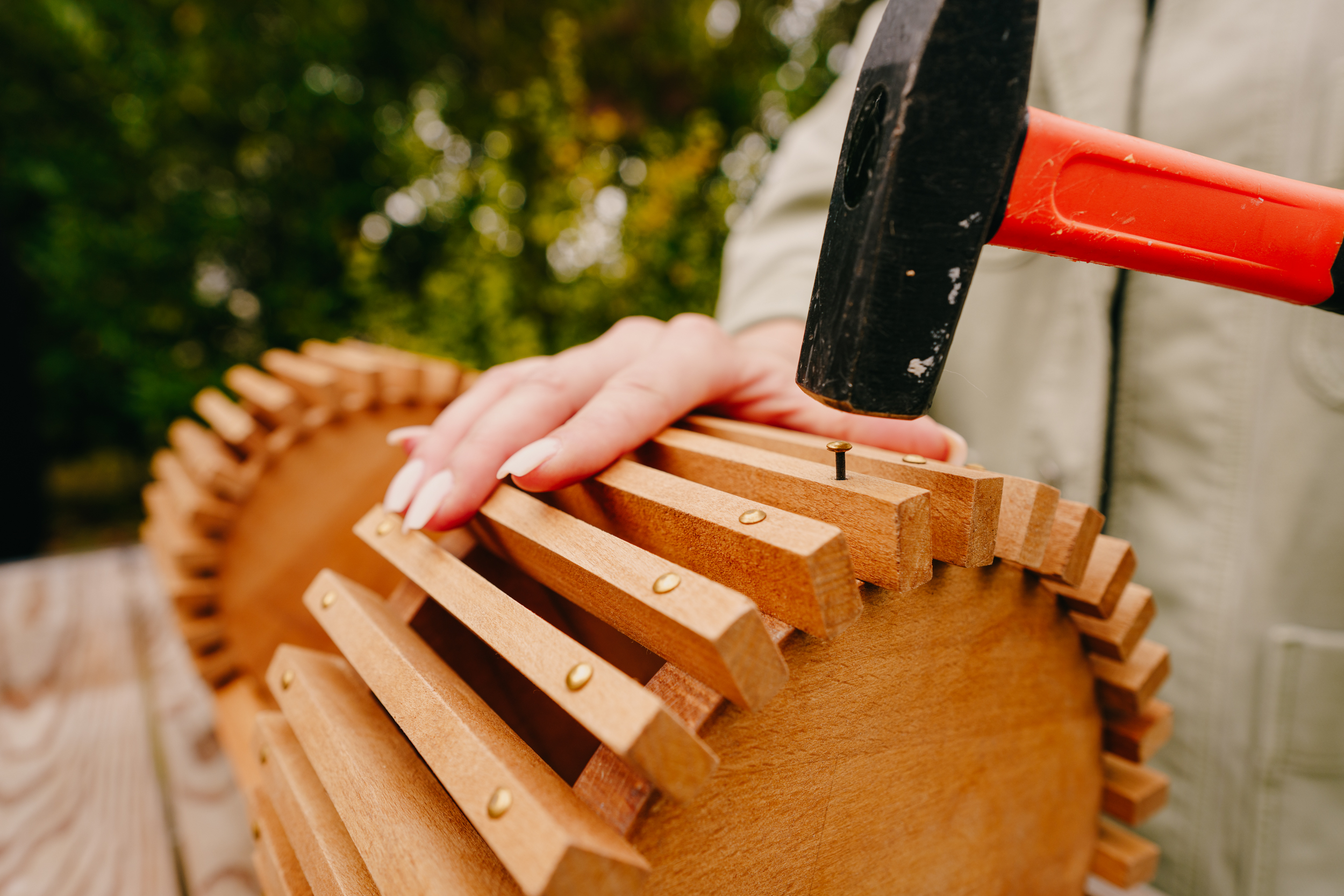 Řemeslnice upevňuje krátké lišty pomocí kladiva a hřebíků