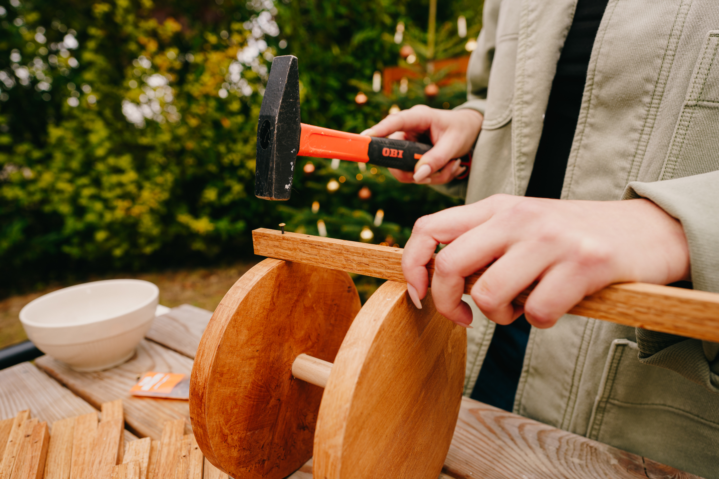 Řemeslnice upevňuje lišty pomocí kladiva a hřebíku
