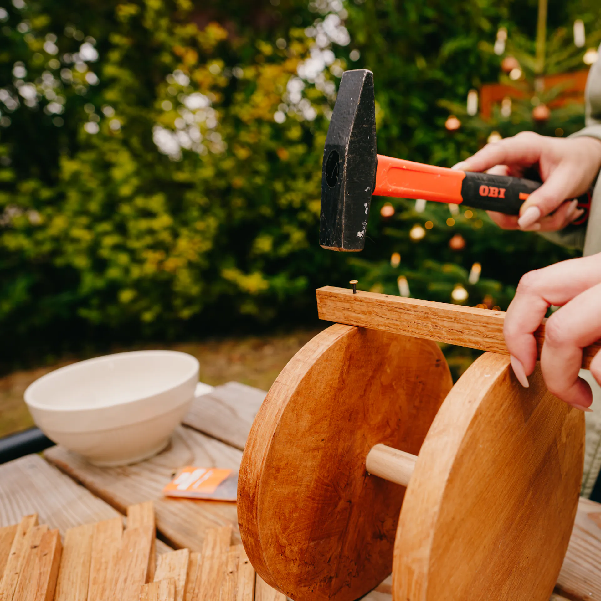 Řemeslnice upevňuje lišty pomocí kladiva a hřebíku