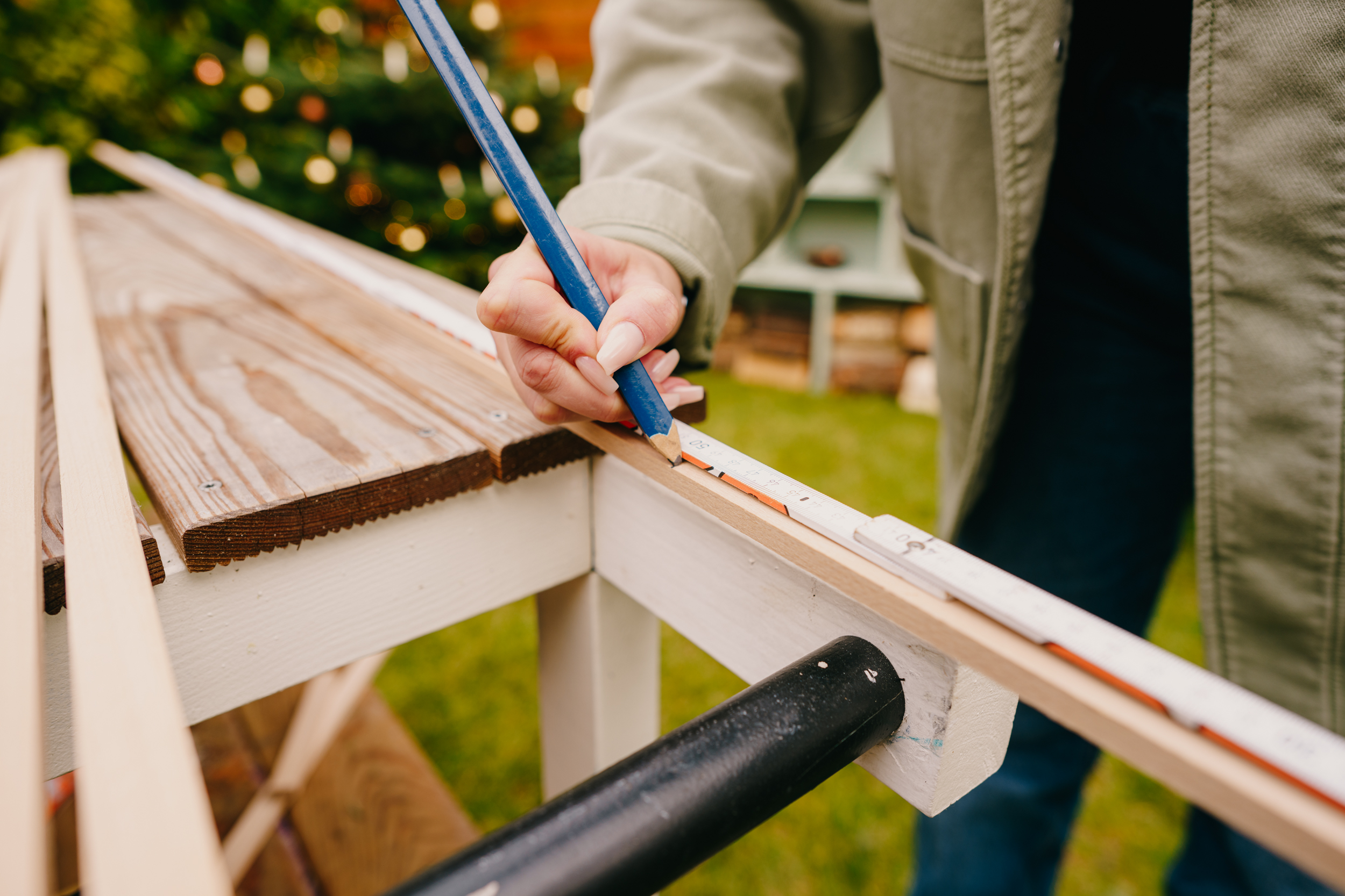 Řemeslnice označuje lišty pomocí tužky a skládacího metru
