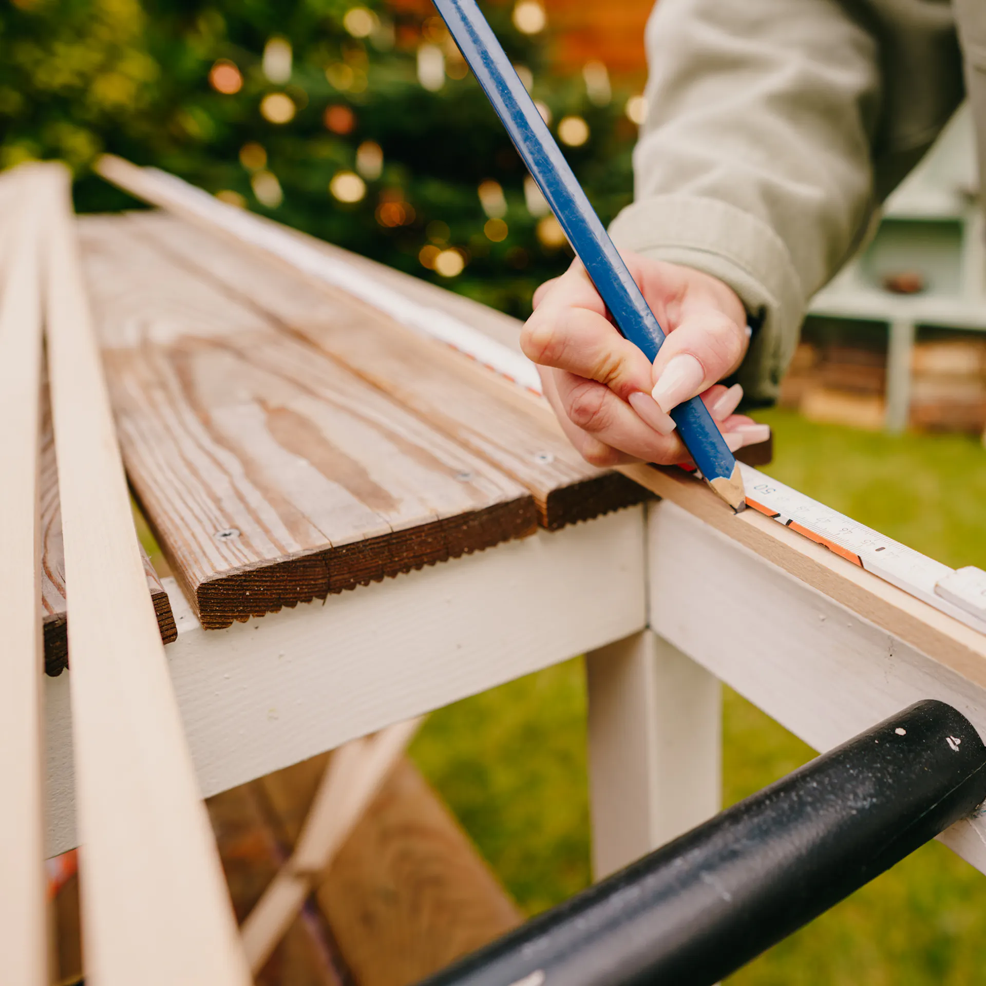 Řemeslnice označuje lišty pomocí tužky a skládacího metru