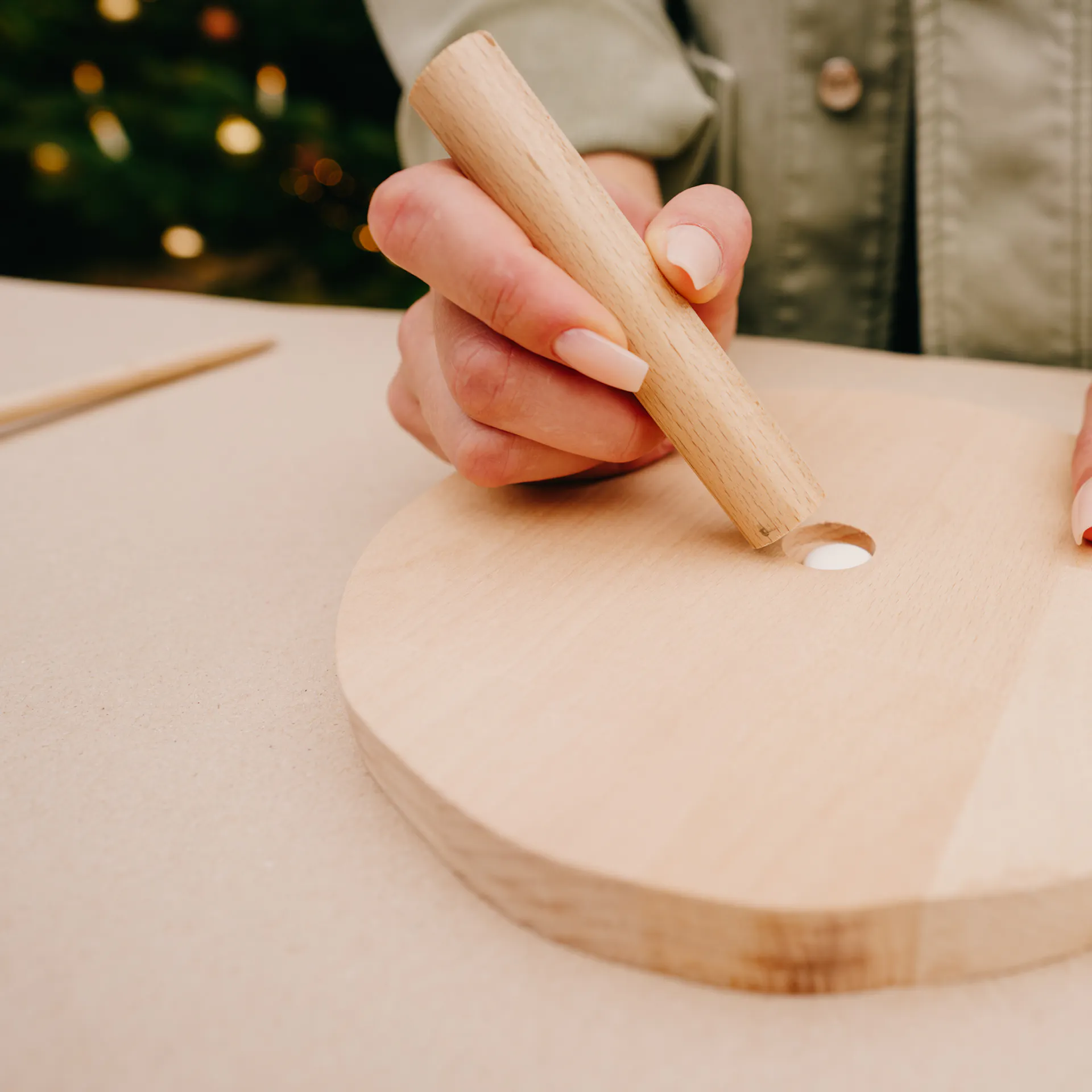 Řemeslnice vsazuje kulatou tyč do předvrtaného otvoru