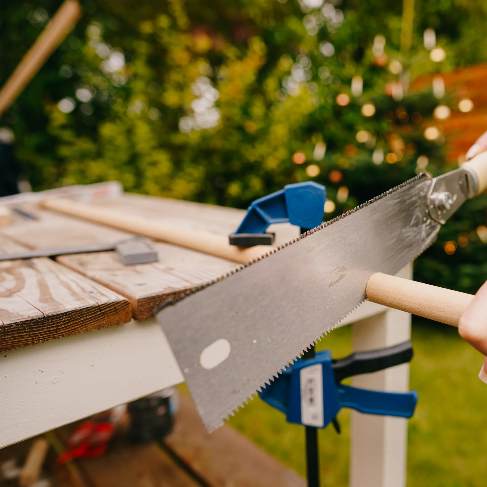 Řemeslnice nařezává kulaté tyče