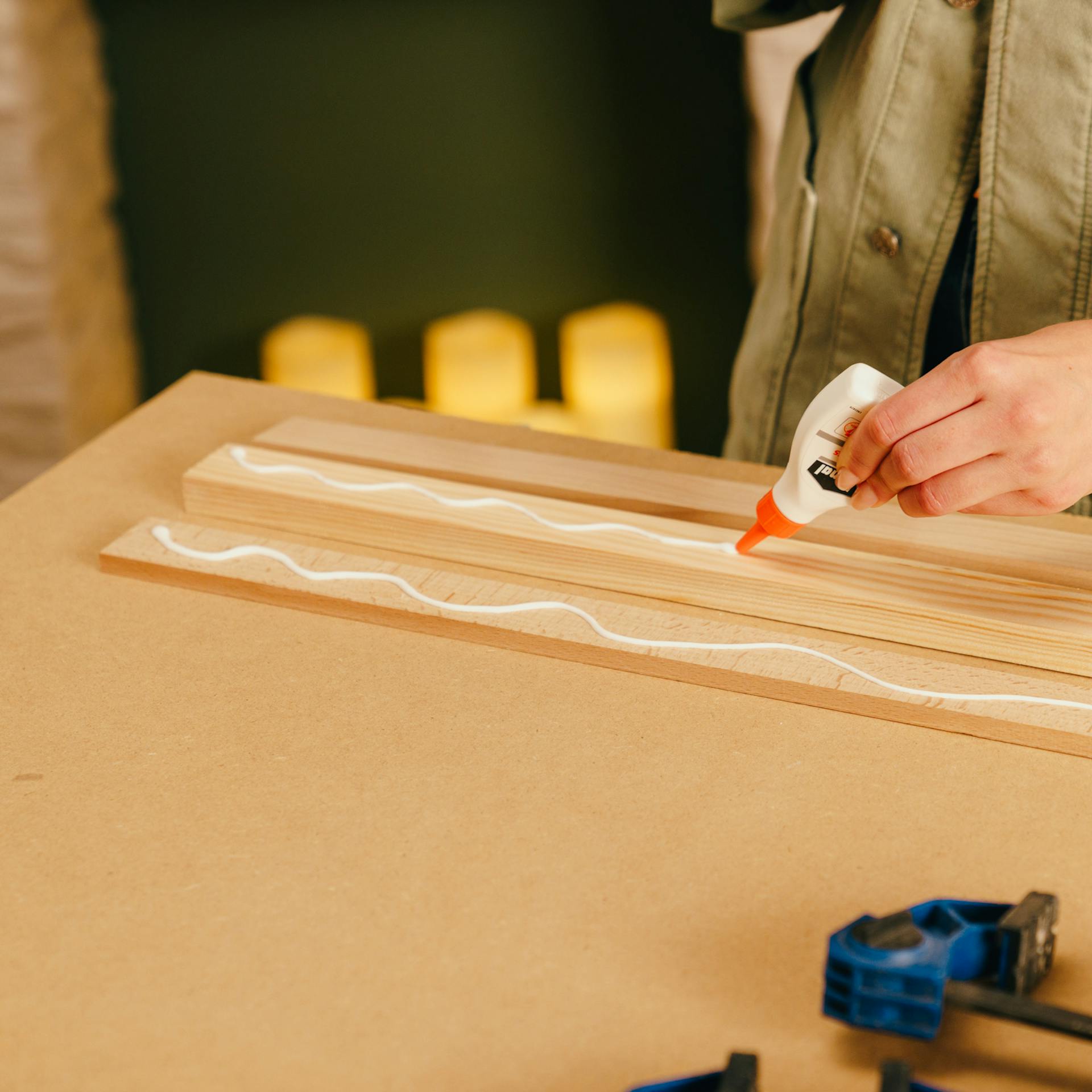 Egy barkácsoló ragasztja a léceket.