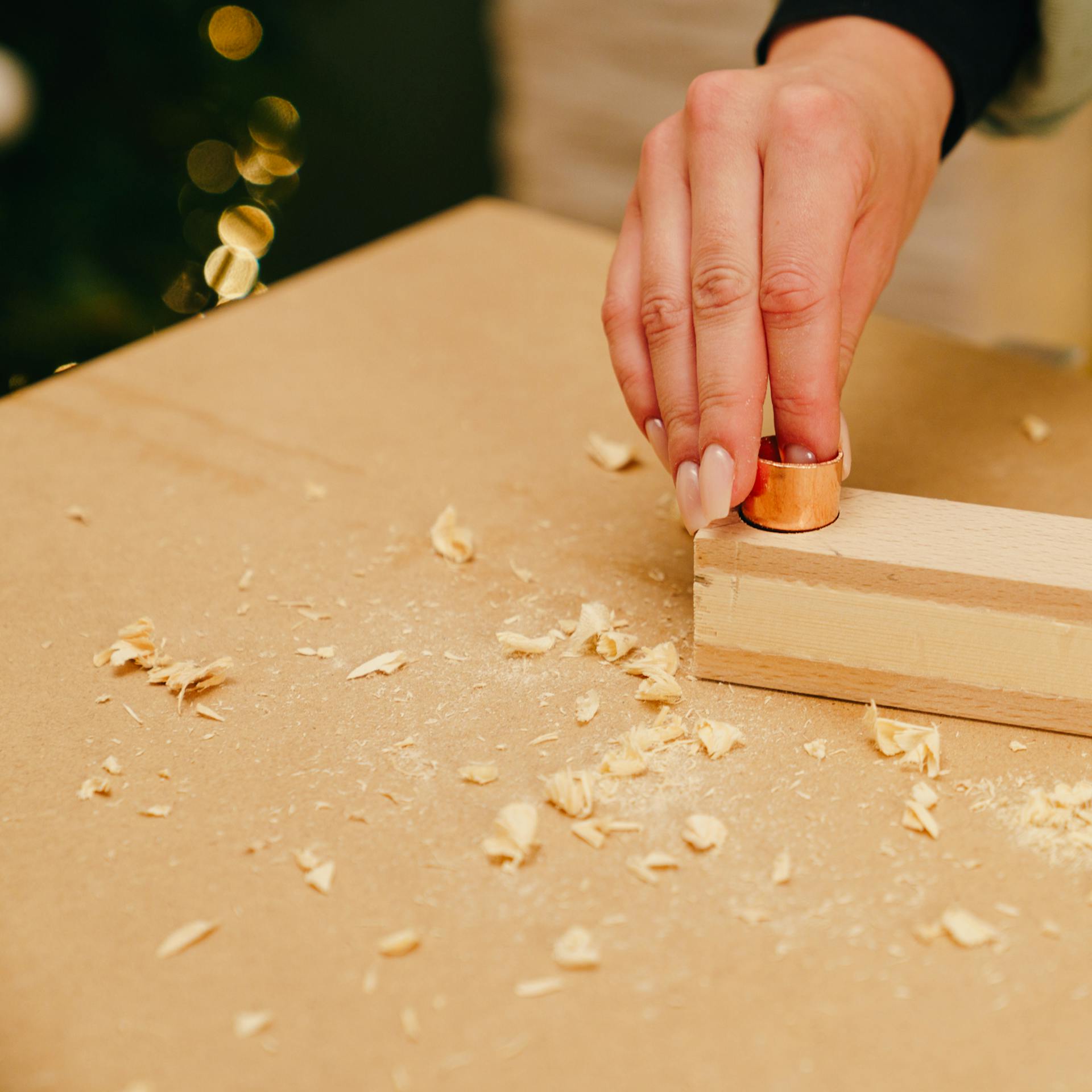 Egy barkácsoló rézcső kupakot tesz a lécszerkezetbe.