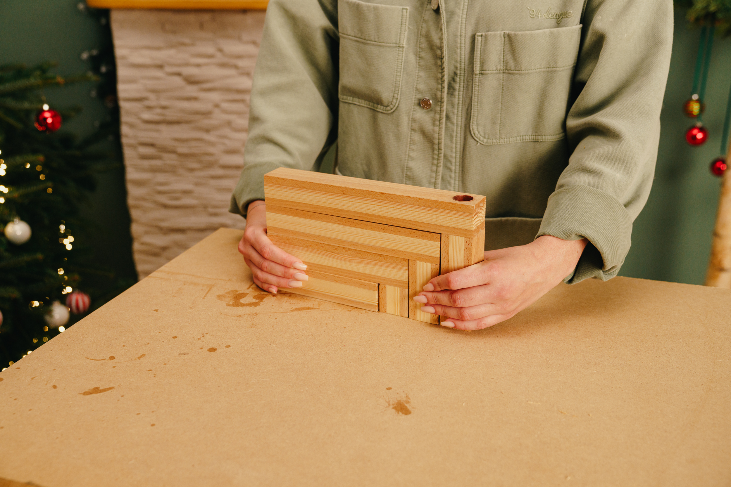 Egy barkácsoló összeállítja a gyertyatartó elemeit.