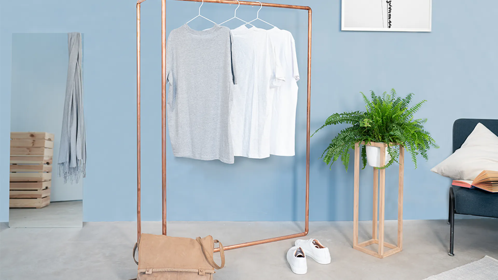 Garderobe aus Kupferrohr mit T-Shirts an Bügeln